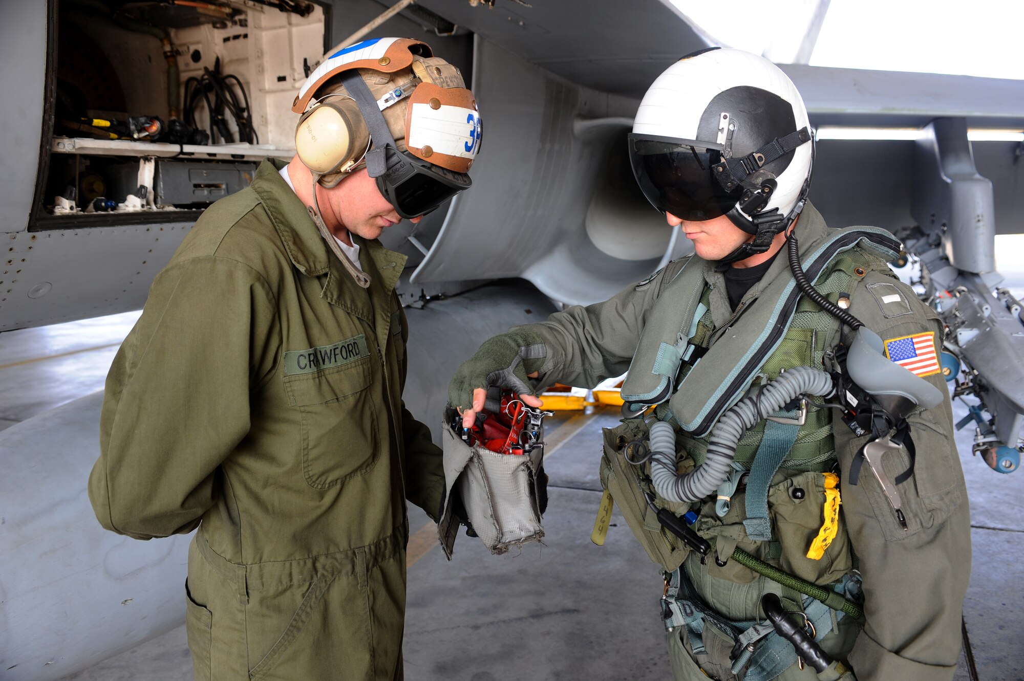 Lt. j.g. James Sorbet, right, counts the amount of remove before flight pins while Aviation Mechanic Dennis Crawford, left, holds them during pre-flight inspection process on a Navy F/A-18 Hornet Aug 13, 2008 at Eielson Air Force Base, Alaska. Navy Strike Fighter Squadron 125, based out of Naval Air Station Lemoore, Calif., is currently conducting air to ground target training here by utilizing the 67,000 square mile Pacific Alaskan Range Complex. During this training new fighter pilots are gaining the qualification they need before they are sent to the fleet. Lieutenant Sorbet is assigned to the VFA-125 Squadron. Seaman Crawford is assigned to the VFA-125 Squadron Augment Unit.  (U.S. Air Force photo by Airman 1st Class Jonathan Snyder)