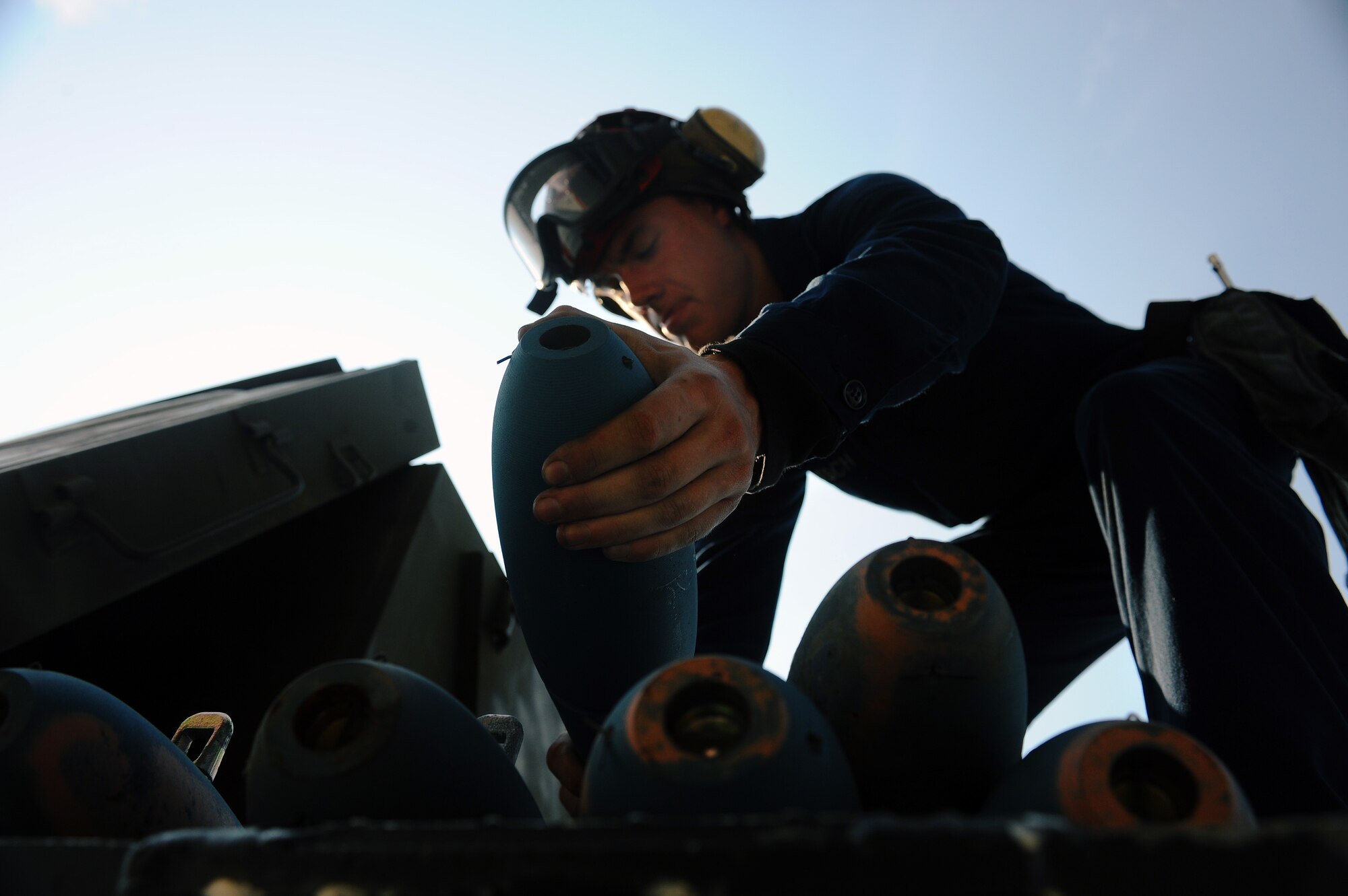 Aviation Apprentice David Haitsch removes several MK-76 practice bombs out of a crate to be carried over to a Navy F/A-18 Hornet Aug. 13, 2008, at Eielson Air Force Base, Alaska. Navy Strike Fighter Squadron 125, based out of Naval Air Station Lemoore, Calif., is currently conducting air to ground target training here by utilizing the 67,000 square mile Pacific Alaskan Range Complex. During this training new fighter pilots are gaining the qualification they need before they are sent to the fleet. He is assigned to the VFA-125 Squadron Augment Unit.  (U.S. Air Force photo by Airman 1st Class Jonathan Snyder)