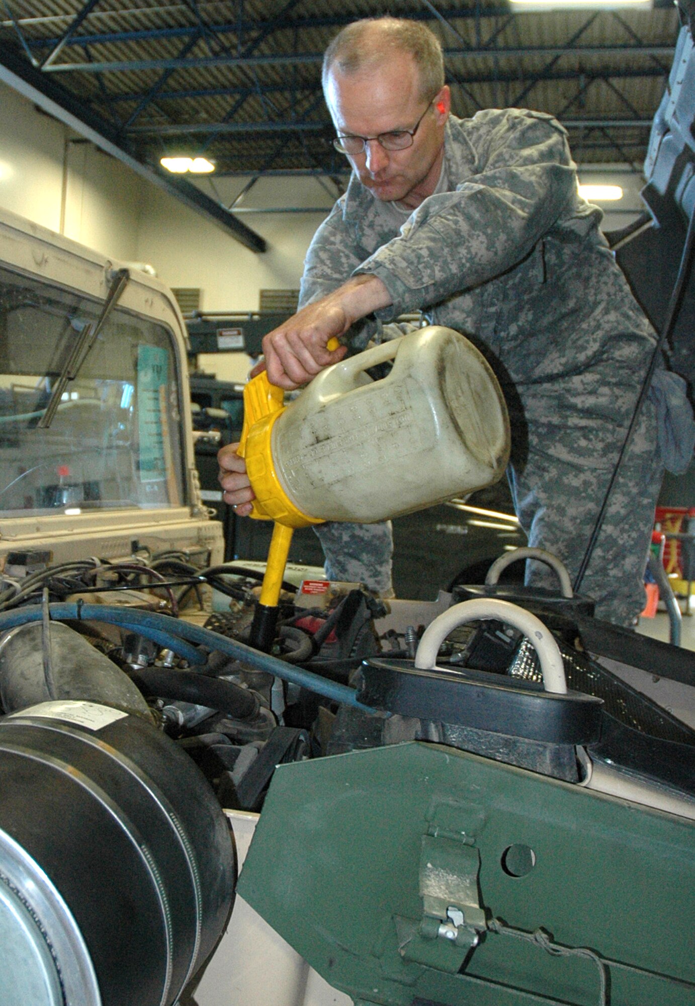 Tech. Sgt. Carl Vickers, a heavy equipment mobile mechanic from the 446th Logistics Readiness Flight, McChord Air Force Base, Wash., adds fluid to a vehicle as part of his duties.  Sergeant Vickers is one of more than 2,400 Citizen Airmen in the 446th Airlift Wing serving our nation.