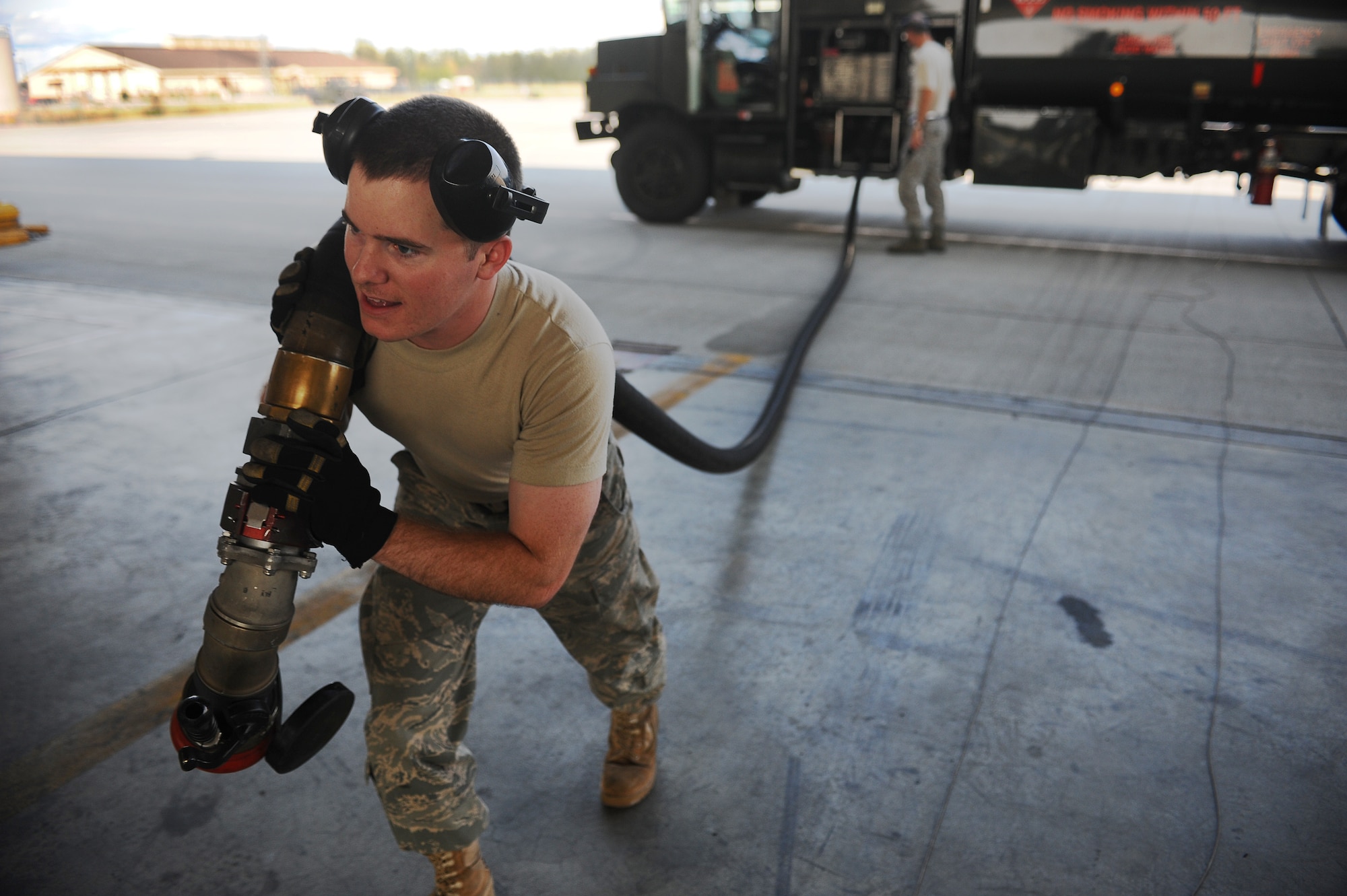 Senior Airman Michael Partain drags a fuel line to a Navy F/A-18 Hornet Aug. 13, 2008, at Eielson Air Force Base, Alaska. Navy Strike Fighter Squadron 125, based out of Naval Air Station Lemoore, Calif., is currently conducting air-to-ground target training here by utilizing the 67,000 square mile Pacific Alaskan Range Complex. During this training new fighter pilots are gaining the qualification they need before they are sent to the fleet. He is assigned to the 354th Logistics Readiness Squadron.  (U.S. Air Force photo by Airman 1st Class Jonathan Snyder)