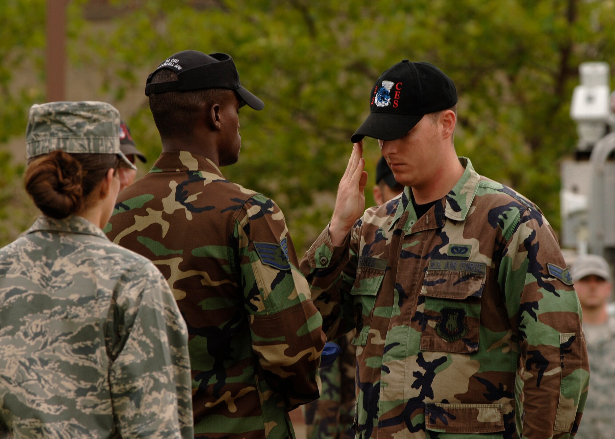 MCCONNELL AIR FORCE BASE, Kan.  -- Airman 1st Class Jesse Stokes, 22nd Civil Engineering Squadron, salutes the American Flag as Staff Sgt. Marlon Washington, 22nd Air Refueling Wing Honor Guard, carries it during a retreat ceremony, Aug. 7. (Photo by Staff Sgt. Jamie Train)