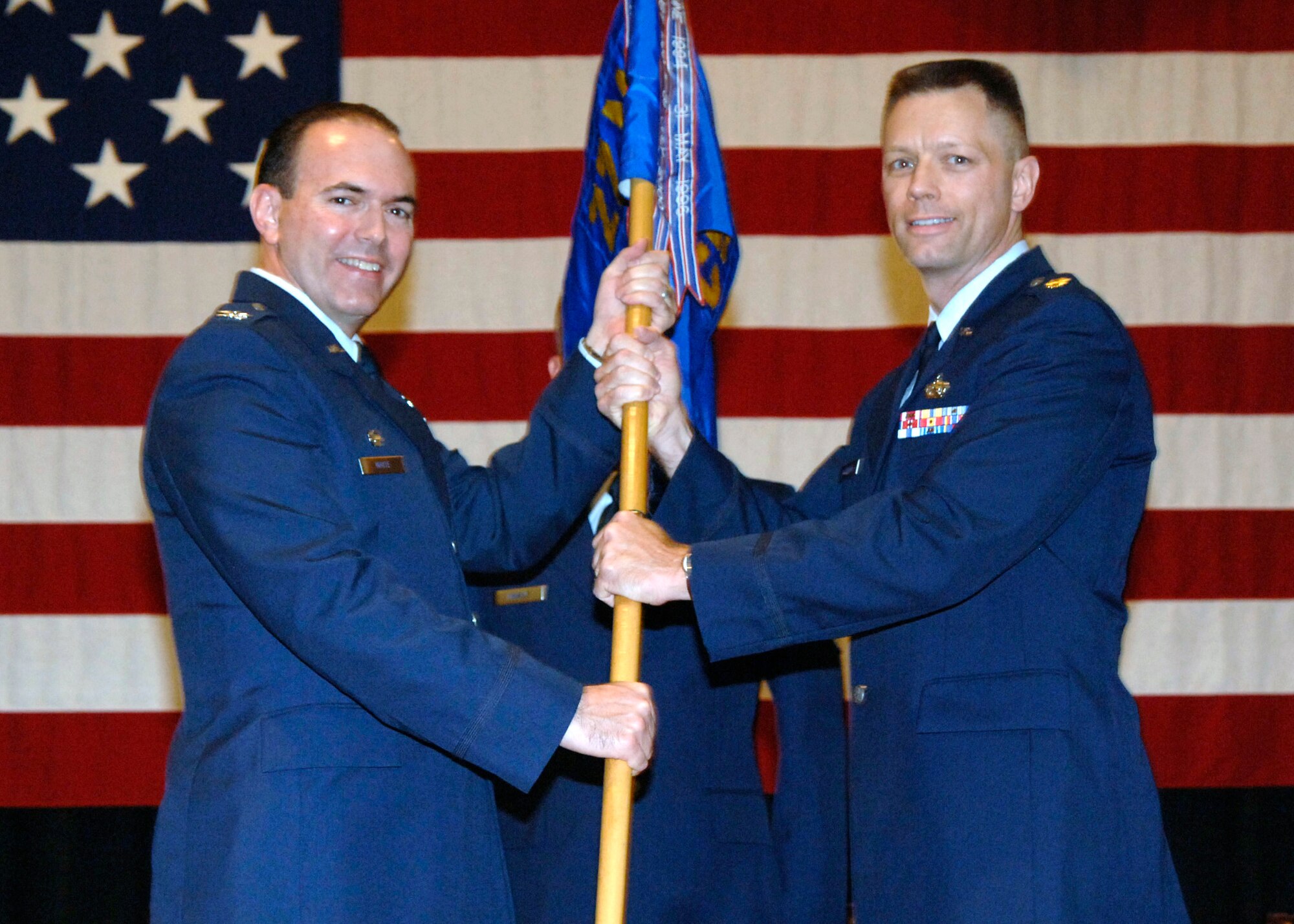 MCCONNELL AIR FORCE BASE, Kan. -- Col. Mark White, 22nd Mission Support Group commander, left, hands a guidon to Maj. Sean Robinson, who takes command of the 22nd Communications Squadron during a change of command ceremony, Aug. 7. (Photo by Senior Airman Anthony Mejia)