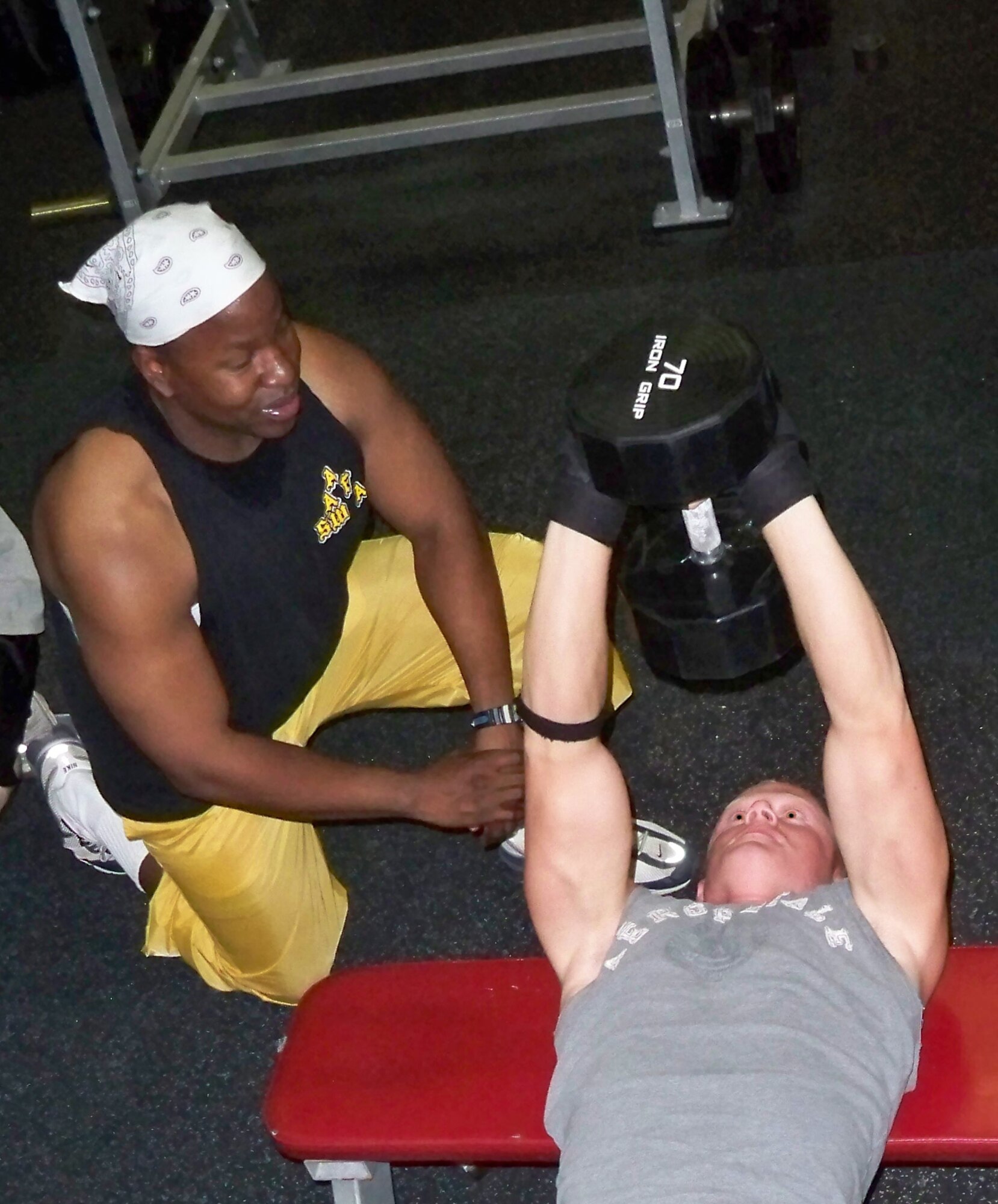 WHITEMAN AIR FORCE BASE, Mo. – Capt. Michael Boswell, 509th Logistics Readiness Squadron and WAFB bodybuilding coach, critiques Airman 1st Class Stephen Linch, 509th Bomb Wing Public Affairs, as he performs triceps presses Aug 13. Airman Linch is one of 12 WAFB Body Building Team members training for upcoming competitions.  (U.S. Air Force photo/Stephanie Fowler)