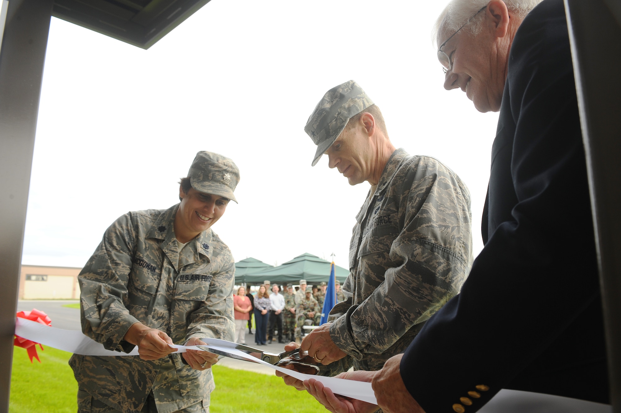 Brig. Gen. Mark Graper, 354th Fighter Wing commander, cuts the ribbon to the new fitness center addition during the official grand opening ceremony Aug. 13, 2008, at Eielson Air Force Base, Alaska. The new addition has an indoor track and field, lifting equipment rooms along with Health and Wellness Center classrooms. Also pictured are Mr. Bill Brophy, right, and Lt. Col. Catherine McGowan, 354th Force Support Squadron commander, (U.S. Air Force photo by Airman 1st Class Jonathan Snyder)