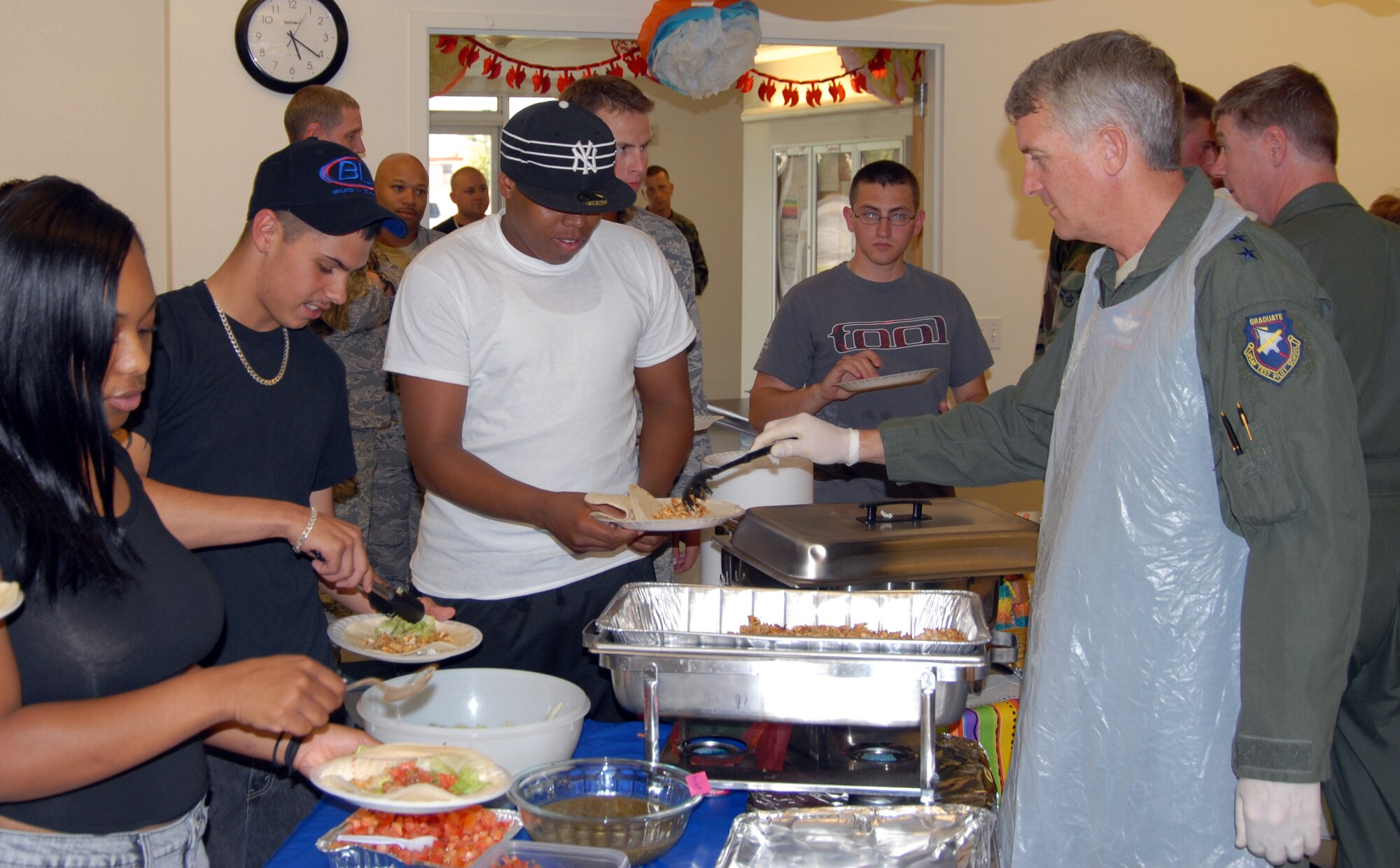 Maj. Gen. David Eichhorn (right), Air Force Flight Test Center commander, serves food to Airmen during a dorm dwellers dinner at the Chapel 1 Annex here Aug. 13. The dorm dinners are free to all dorm residents from both the Air Force and Marine Corps. (Air Force photo by Airman 1st Class William O'Brien)