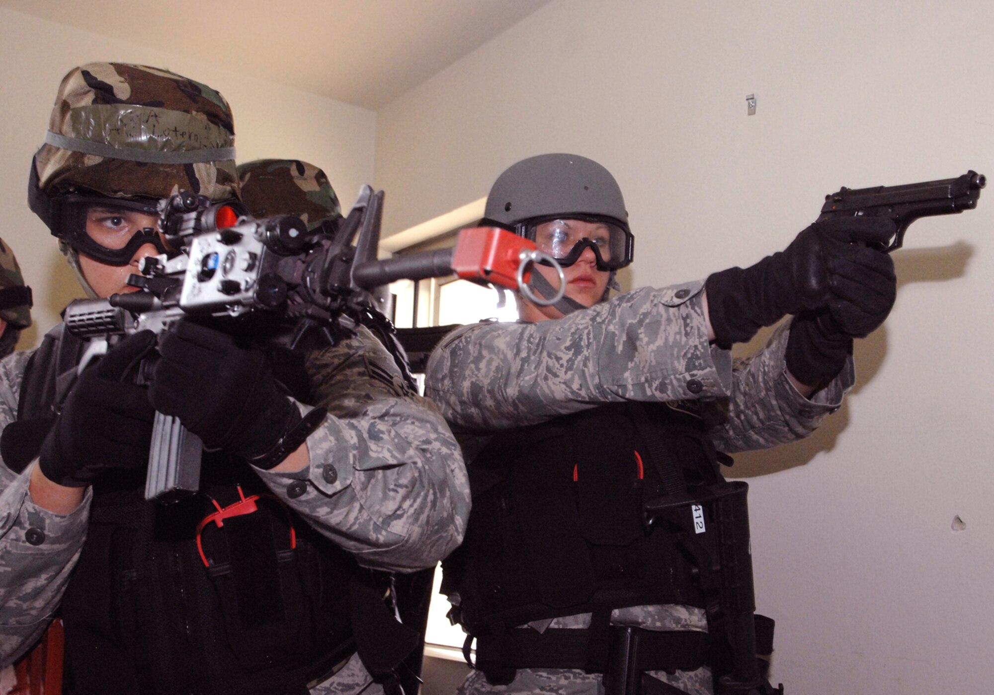 SPANGDAHLEM AIR BASE, Germany --  Airman First Class Isaac Lotero and Airman First Class Britanny Chalut, 52nd Security Forces Squadron, work together to secure their team’s exit from a building during a room clearing exercise, Aug. 8, 2008.  Both Airmen were part of a five-day combat skills training course that taught SFS Airmen to enter and clear buildings during special response situations.  ( U.S. Air Force photo by Staff Sgt. Logan Tuttle )