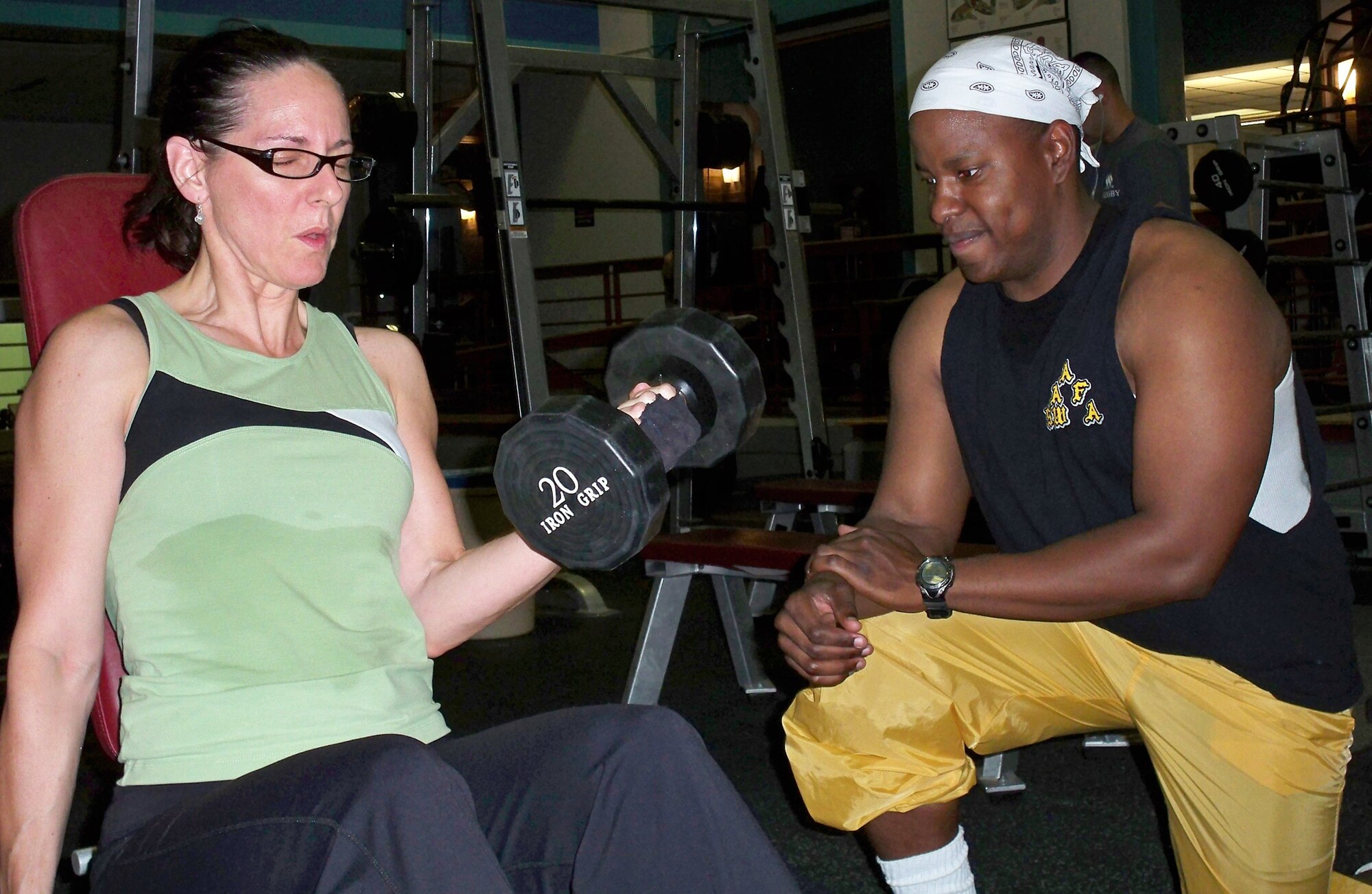WHITEMAN AIR FORCE BASE, Mo. – Capt. Michael Boswell, 509th Logistics Readiness Squadron and WAFB bodybuilding coach, critiques Murica Simmering, WAFB Bodybuilding team member, as she performs curls Aug. 13. Mrs. Simmering is one of 12 WAFB Body Building Team members training for upcoming North American National Bodybuilding Federation bodybuilding competitions. (U.S. Air Force photo/Airmen 1st Class Stephen Linch) 