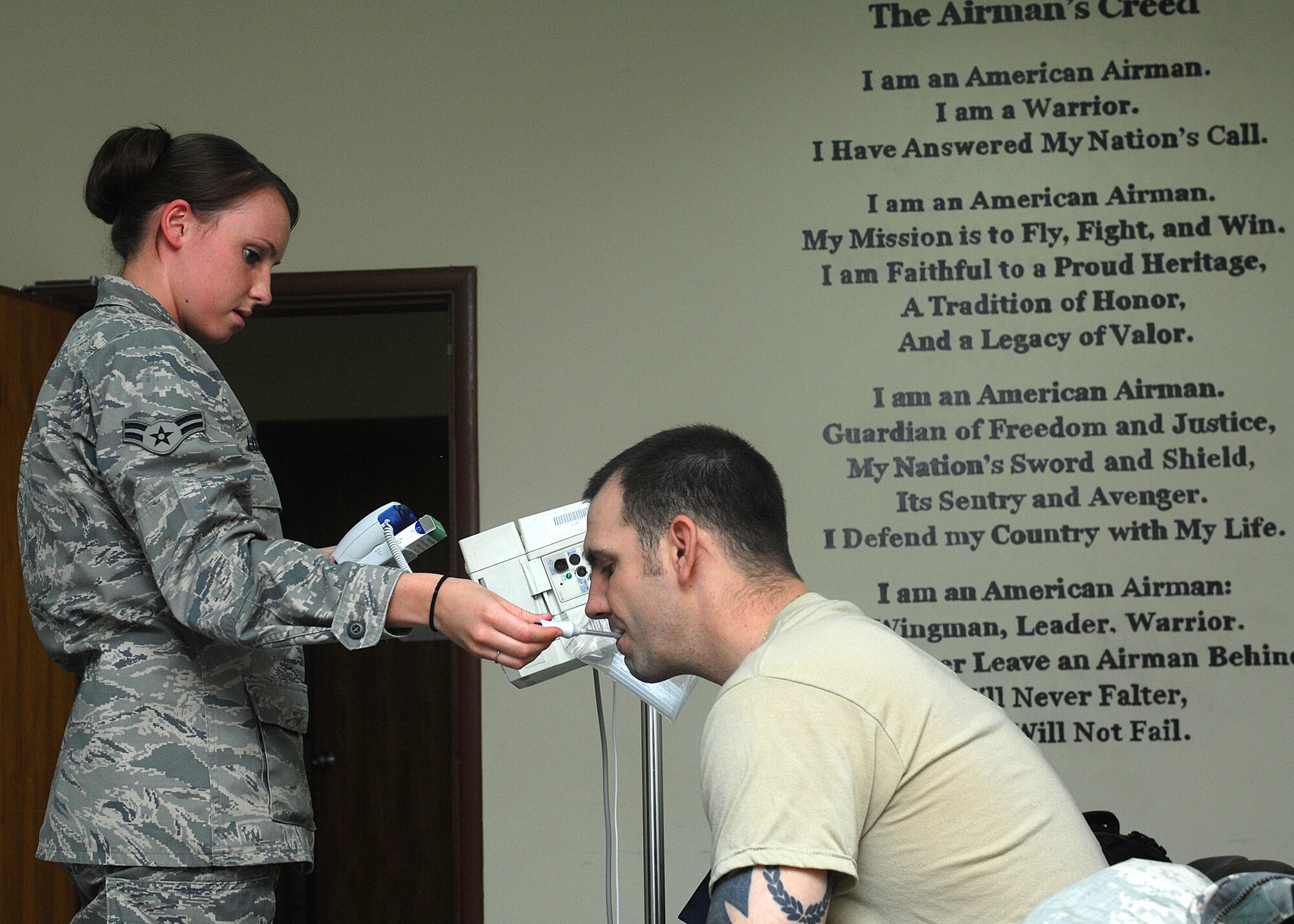 SOUTHWEST ASIA -- Airman 1st Class Nikayla Locher, 386th Expeditionary Medical Group, takes the temperature of a patient who is being admitted to the Contingency Aeromedical Staging Facility at an air base in Southwest Asia. Patient vitals are taken by CASF medical technicians upon entry at the CASF and every 12 hours until their departure to medical centers in Europe or the continental U.S. Airman Locher is deployed from Wright-Patterson Air Force Base, Ohio. (U.S. Air Force photo/Tech. Sgt. Raheem Moore)