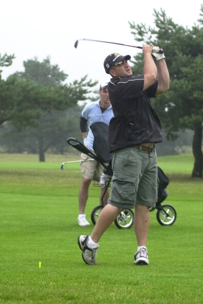 Robby Jackson, 100th Aircraft Maintainance Squadron, plays a short iron shot into the 16th green during the Joan Mann Golf Tournament at Breckland Pines Golf Club, Aug. 8. The best ball scramble format was used for the competition to raise funds for the Joan Mann Special Sports Day. (Air Force photo by Gary Rogers)                        
