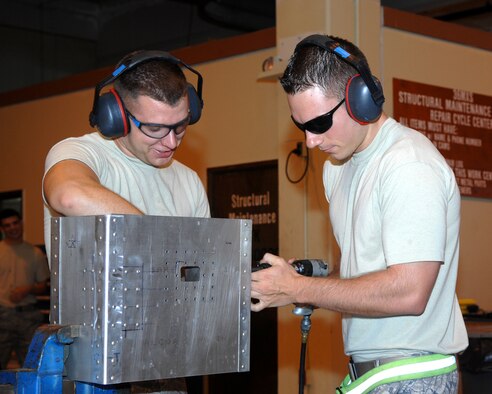 ANDERSEN AIR FORCE BASE, Guam - Airman 1st Class Jake Sides and Senior Airman Jason Gergen, 389th Expeditionary Aircraft Maintenance Squadron, fasten bolts onto a box Aug. 14. The Airmen is part of the aircraft structural maintenance shop deployed here from Mountain Home AFB, Idaho. The aircraft maintenance shop uses metalworking equipment and tools to form, cut, bend and fasten replacement or repair parts to damaged structures and components. (U.S. Air Force photo by Airman 1st Class Cory Todd)