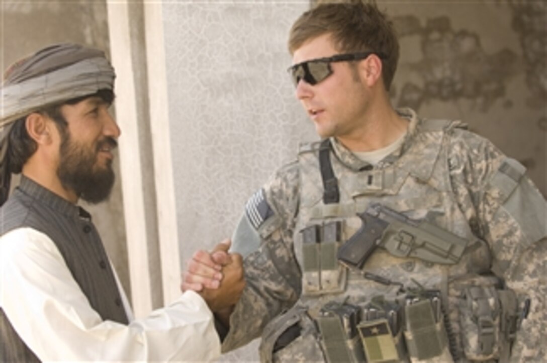 U.S. Air Force 1st Lt. Adam Lazar discusses the construction of a new fire station with a resident in Qalat, Afghanistan, on Aug. 10, 2008.  Lazar, an engineer with the Zabul Provincial Reconstruction Team, oversees more than 20 construction projects contracted out to local firms.  