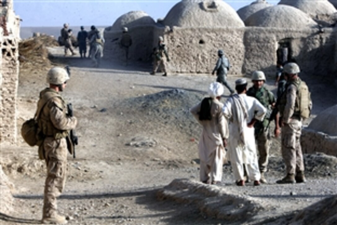 U.S. Navy sailor Benjamin Thiel, left, a hospital corpsman, provides security while patrolling through a village in Farah province in Afghanistan, July 31, 2008. Thiel is assigned to Golf Company, 2nd Battalion, 7th Marine Regiment.