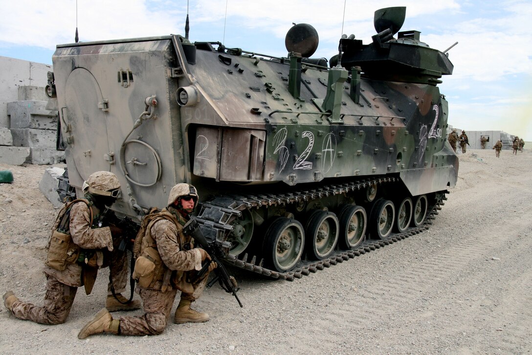 Lance Cpl. Brian Greene and Hospitalman Robert Cooper from 2nd Platoon, Company F, 2nd Battalion, 25th Marine Regiment take cover behind their amphibious assault vehicle in the town of “Ridwaniyah,” a military operations in urban terrain facility on Range 210 at Marine Corps Air Ground Combat Center in Twentynine Palms, Calif. on Aug. 14, 2008.  Marines from 2nd Amphibious Assault Battalion, 2nd Marine Division based in Camp Lejeune, N.C. traveled across the country earlier this month to support the reservists’ pre-deployment training.