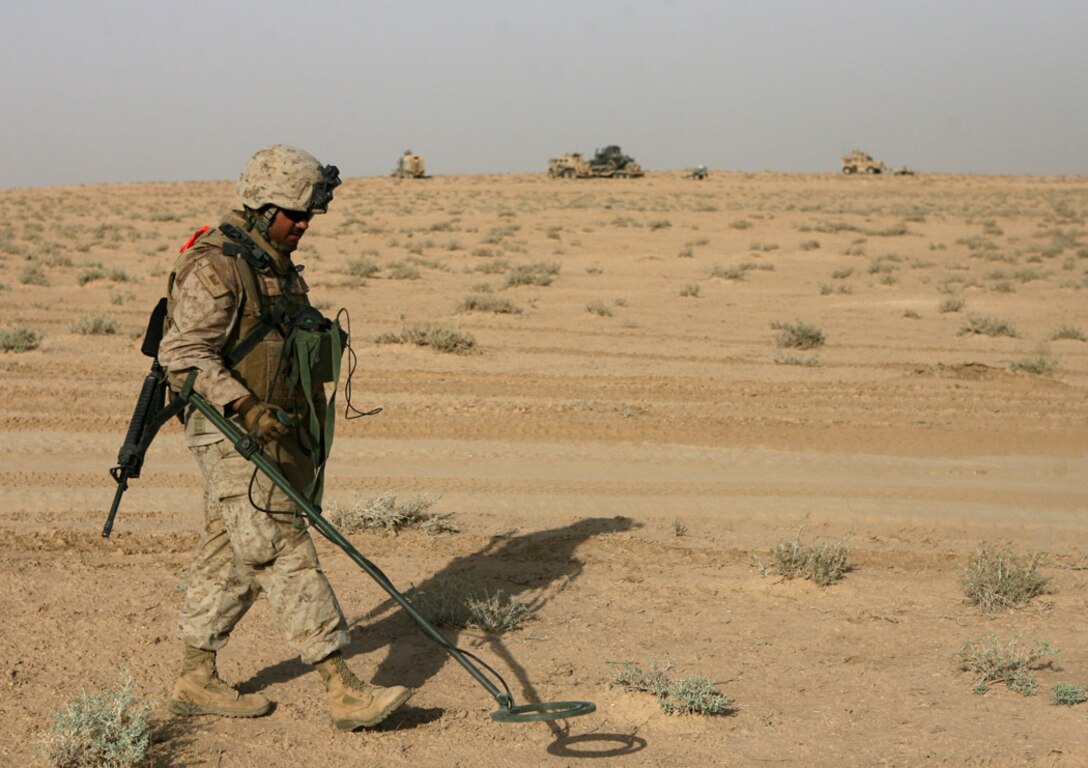 Lance Cpl. Enoch E. Chavarria, 21, a combat engineer with Route Clearance Platoon, Company A, 3rd Combat Engineer Battalion, Regimental Combat Team 5, walks with a mine detector Aug. 14 while searching for mines on the Iraq and Syrian border. The platoon marked two minefields and detonated six mines. Route Clearance Platoonâ??s responsibilities normally include patrolling the roadways of Iraq to ensure the safe travel of Coalition forces. Though trained in explosives, this is the first time this deployment that the platoon has detonated any explosives they have found.