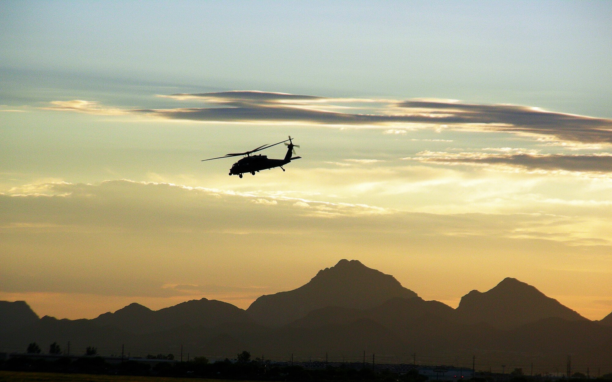 DAVIS-MONTHAN AIR FORCE BASE, Ariz. - A 920th Rescue Wing HH-60G Pave Hawk helicopter pierces the desert sky over the southern-Arizona mountains as part of two-weeks of high-altitude training as pilots and aircrews from the 920th Rescue Wing here trained July 12-25 at Davis-Monthan Air Force Base, Ariz. Aircrews and maintainers worked day and night to gain high-altitude experience prior to their upcoming deployment to Afghanistan. The country is known for having the roughest terrain with some of the highest mountains in the world. (U.S. Air Force Photo/Capt. Cathleen Snow)