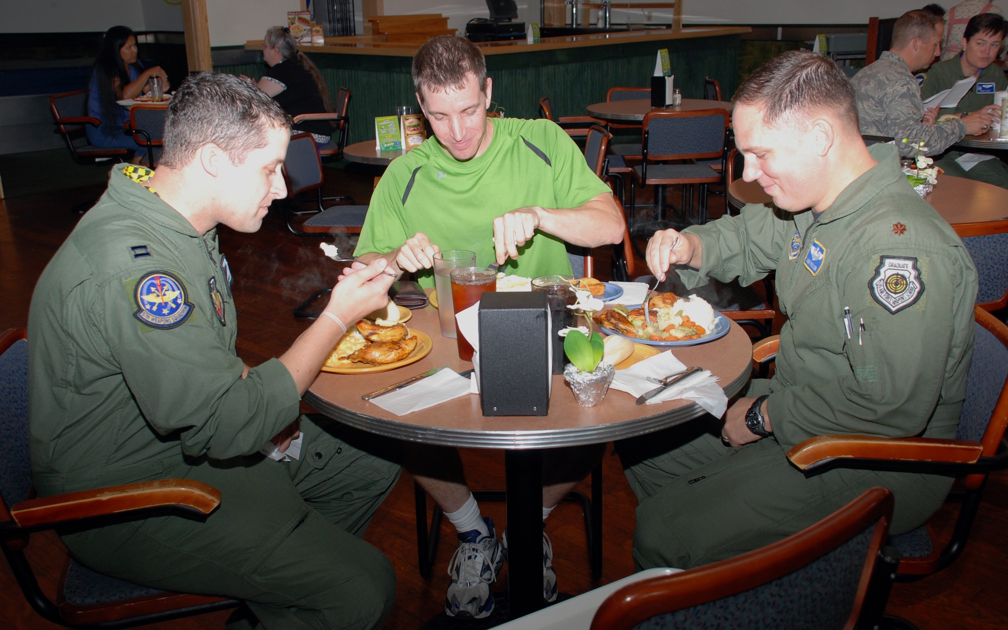 Left to right, Capt. Chuck Polomsky, 57th Weapons Squadron pilot scheduler, Maj. Phil Lynch, 57th WPS course manager, and Maj. Jimmy Fuller, Air Mobility Command headquarters combat operations divison, Scott AFB, Ill., enjoy lunch together at Wright Bros. Café Aug. 15. Today marks the final day of business for the café, which has been open since April 2000. (U.S. Air Force photo/Airman 1st Class Bekah Phy) 