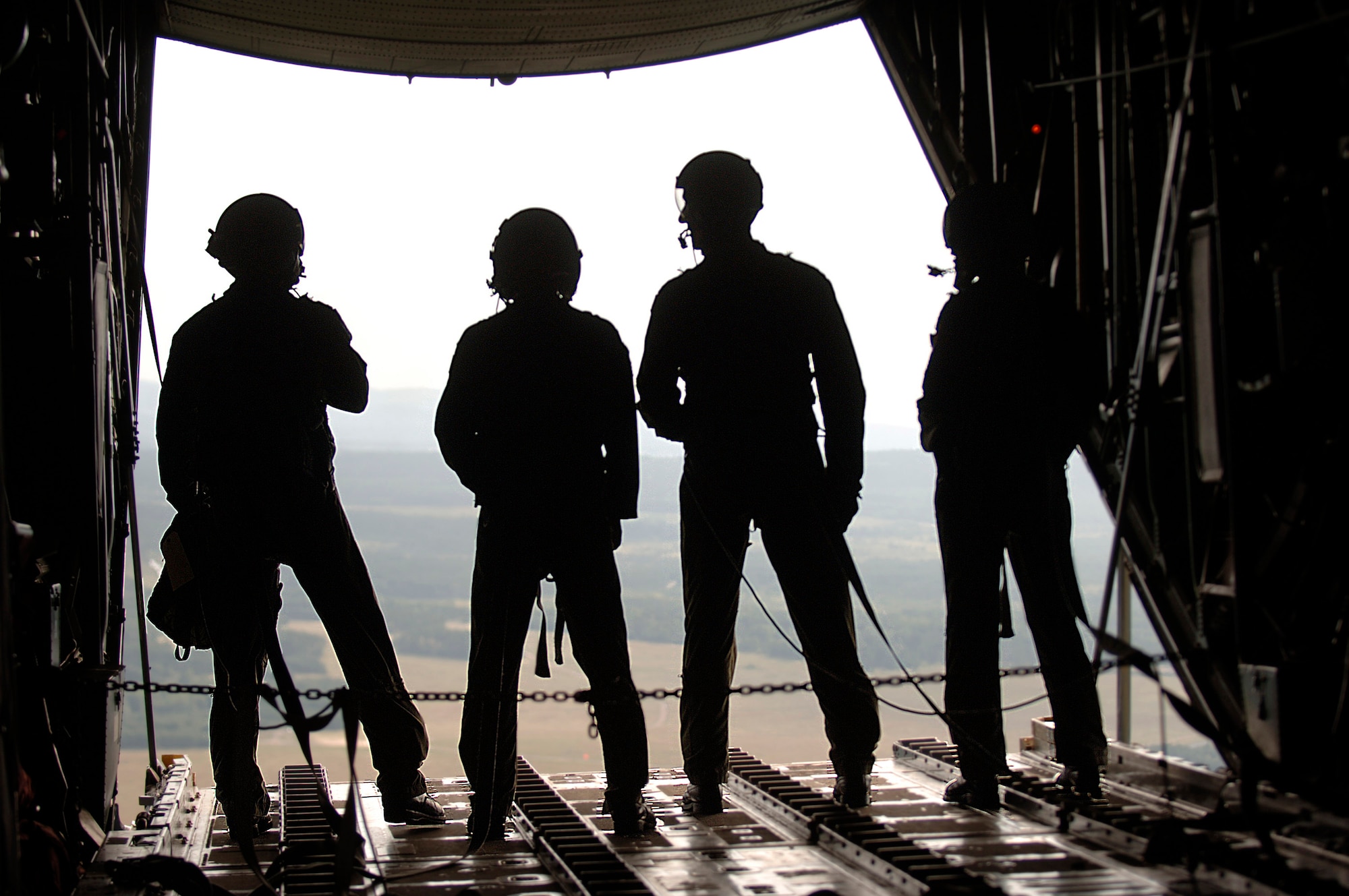 Moments after airdropping cargo over eastern Germany, C-130 loadmasters, Staff Sgt. Dan Insurriaga and Senior Airman Matthew Merkely, (center) invite Air Force Academy Cadet 1st Class Matt Sparta (far left) and Cadet 2nd Class Erin Keane to view the drop zone from the end of the cargo ramp. (U.S. Air Force photo/Master Sgt. Scott Wagers) 