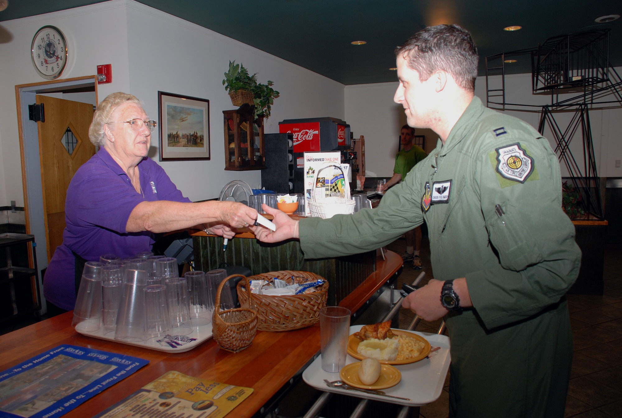 Capt. Chuck Polomsky, 57th Weapons Squadron pilot scheduler, pays for his lunch at Wright Bros. Cafe Aug. 15. Today marks the final day of business for Wright’s Brothers Cafe, which has been open since April 2000. Sheila McCrelles, cashier and shift leader, has worked at Wright Bros. Café since the doors first opened. (U.S. Air Force photo/Airman 1st Class Bekah Phy)