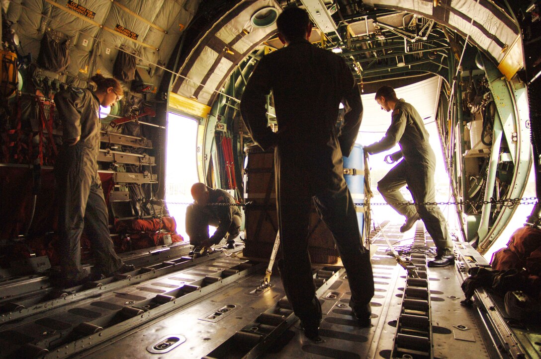 Before an airdrop mission over eastern Germany, Air Force Academy Cadet 2nd Class Erin Keane (left) and Cadet 1st Class Matt Sparta observe  the preflight duties of C-130 Hercules loadmasters, Staff Sgt. Dan Insurriaga and Senior Airman Matthew Merkely. The cadets were participating in a hands-on, job shadow program called Operation Air Force. (U.S. Air Force photo/Master Sgt. Scott Wagers)
