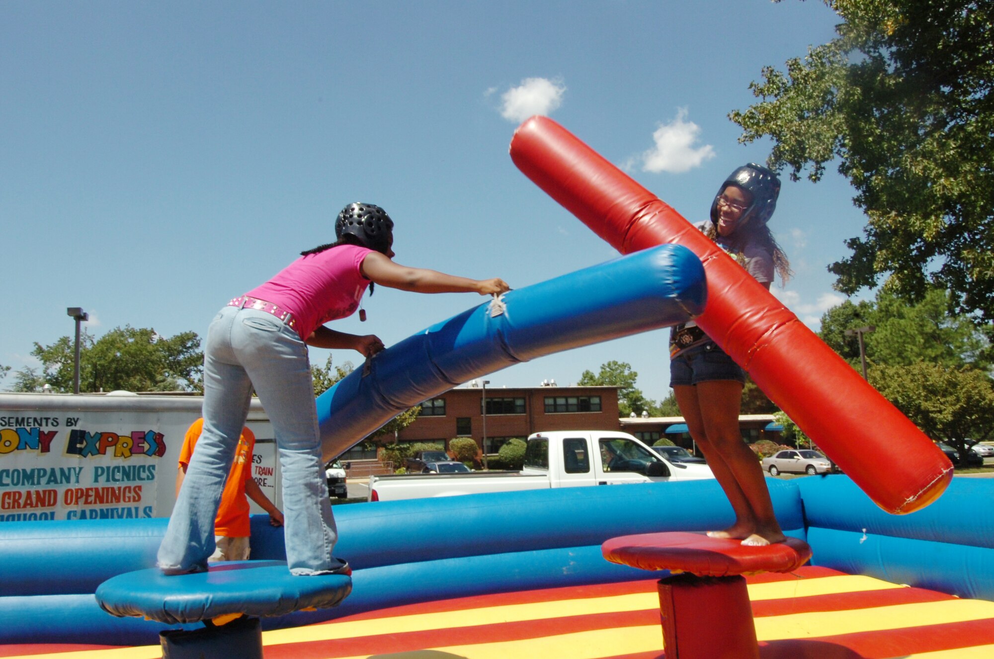 Sisters, Cheryl Stone, 16, left, and Chaire Stone, 19, battle away with giant-size pugo sticks during a jousting match.  Hosted by the 316th Services Squadron, members were treated to free food, beverages and several fun activities. More than 4,000 military members, civilians and their families attended the day-long event. The annual event is held to thank base employees and their families.