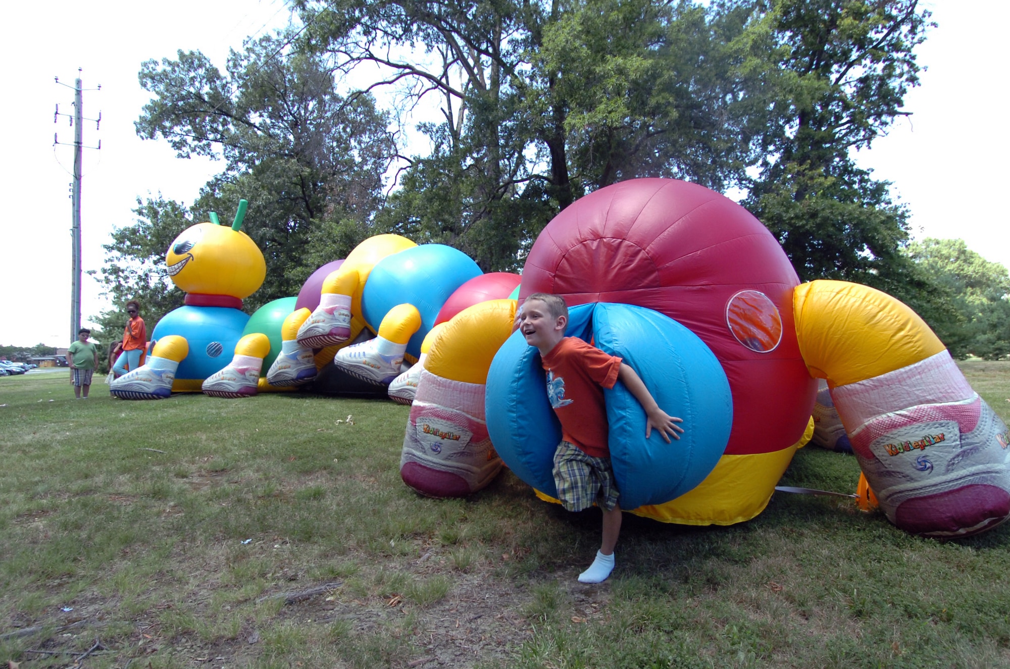 Kross Moore, 6, emerges from the end of a catepillar during the annual Family Fun Day held near the West Fitness Center. Hosted by the 316th Services Squadron, members were treated to free food, beverages and several fun activities. More than 4,000 military members, civilians and their families attended the day-long event. The annual event is held to thank base employees and their families.