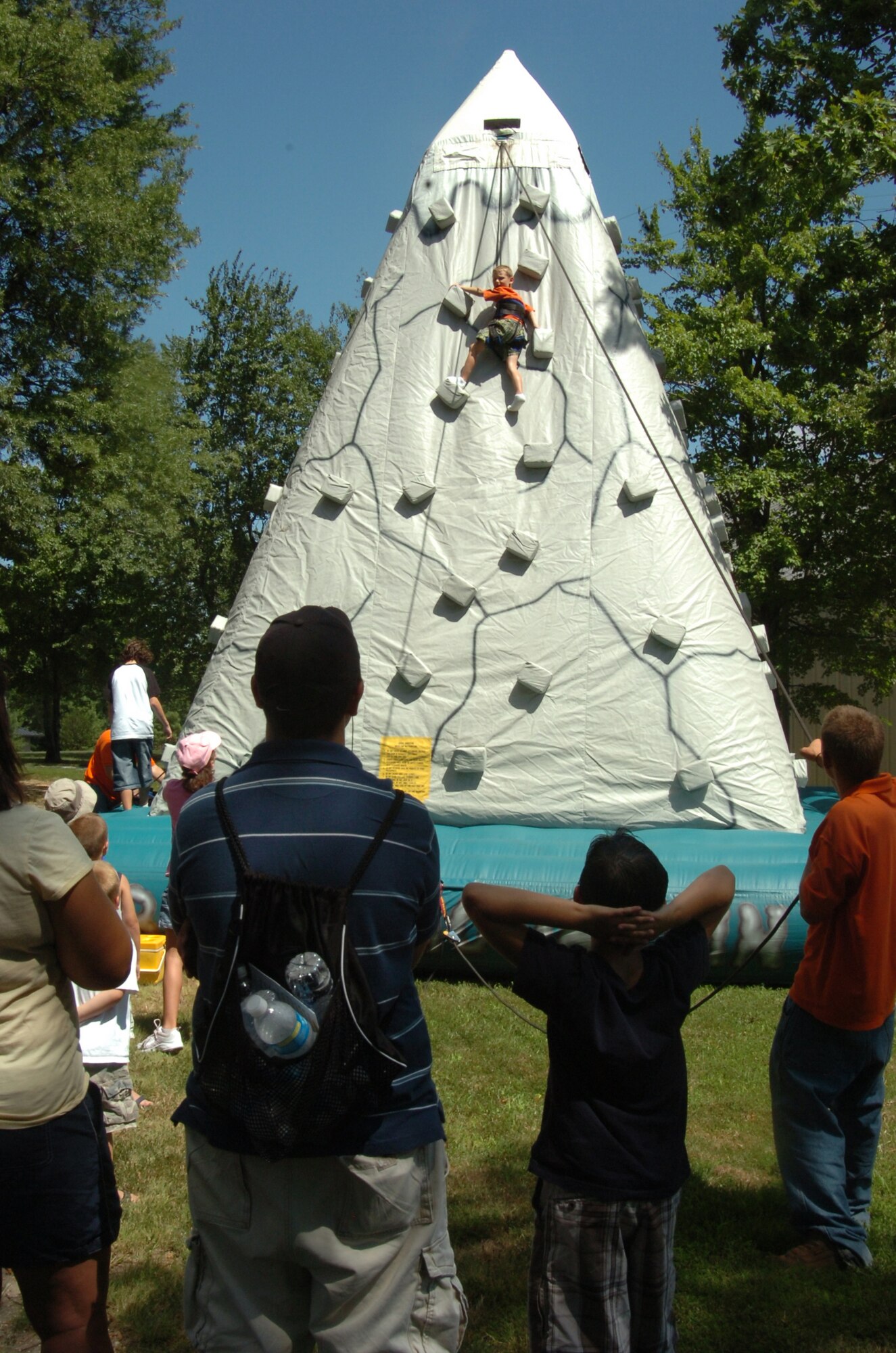 A youngster scales a rock wall mountain as others await their turn. Hosted by the 316th Services Squadron, members were treated to free food, beverages and several fun activities. More than 4,000 military members, civilians and their families attended the day-long event. The annual event is held to thank base employees and their families.
