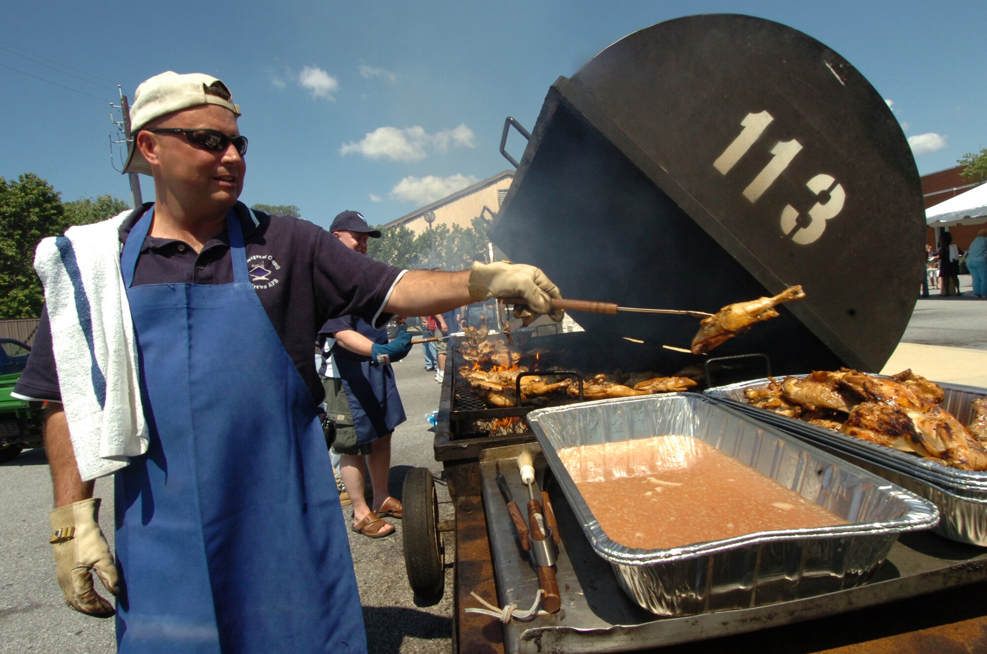 Master Sgt. John Turner, 79th Medical Operations Squadron 1st sergeant removes barbeque chicken from the grill. Approximately 1,500 pounds of barbeque chicken, 650 pounds of hamburger and 650 pounds of hotdogs were prepared. Hosted by the 316th Services Squadron, members were treated to free food, beverages and several fun activities. More than 4,000 military members, civilians and their families attended the day-long event. The annual event is held to thank base employees and their families.