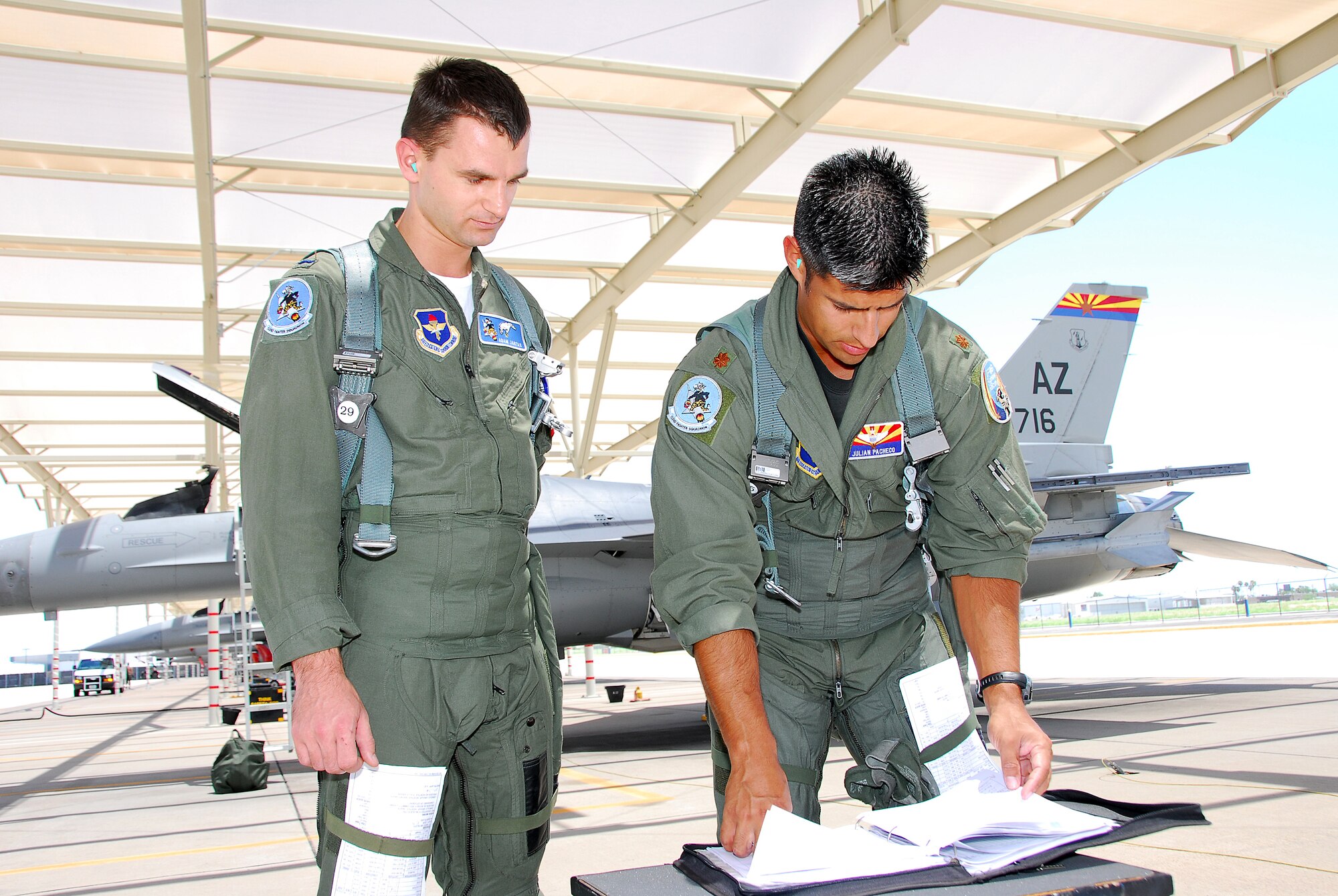 First Lt. Adam Jantas (left), a Polish Air Force student pilot, goes over his morning sortie with F-16 instructor pilot Maj. Julian Pacheco on the 162nd Fighter Wing flightline. (Air National Guard photo by Master Sgt. Dave Neve)