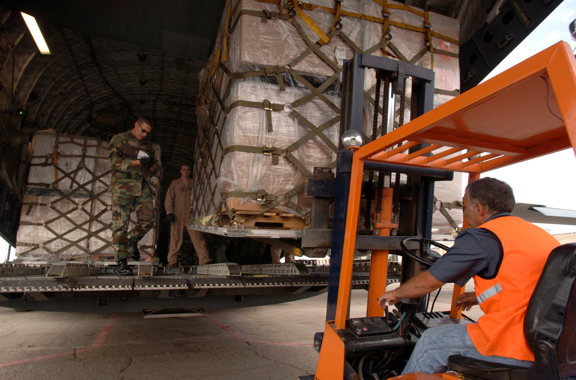 Aerial Transporter Staff Sgt. Chris Droegemueller and C-17 Loadmaster Staff Sgt. Donald Jones deliver the second wave of humanitarian aid to a Republic of Georgia forklift driver, Aug. 14. The delivery was a joint-service effort between U.S. Army Europe Soldiers, U.S. Air Forces Europe and Air Mobility Command Airmen. The Airmen are assigned to the 86th Contingency Response Group at Ramstein Air Base, Germany, and the 6th Airlift Squadron, McGuire AFB, N.J.  (U.S. Air Force photo/Master Sgt. Scott Wagers)
