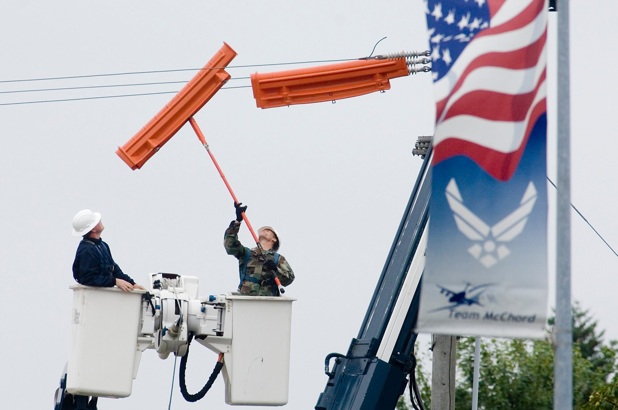 Staff Sgt. John Cote, 62nd Civil Engineer Squadron, places protective covers on utility cables prior to examining the air switch on a utility pole recently along Barnes Boulevard. The mission of the 62nd Civil Engineer Squadron is to provide, operate, sustain, develop and protect the base and its infrastructure.