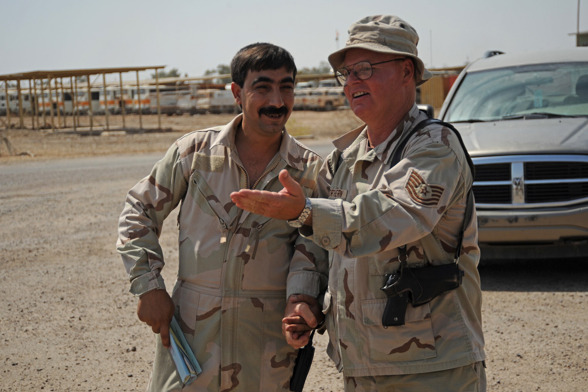 U.S. Air Force Tech. Sgt. Tim Northern (right), fuels advisor for the Coalition Army Advisory Training Team, talks with Iraqi army Warrant Officer Mohammed, at Taji Military Base, Iraq on August 6, 2008. The two men keep meticulous records of the amount of fuel that is delivered to the base. Northern is deployed from the 21st Logistics Readiness Squadron, Peterson Air Force Base, Colo. and is a Colorado Springs native. (U.S. Air Force photo/Staff Sgt. Paul Villanueva II/Released)