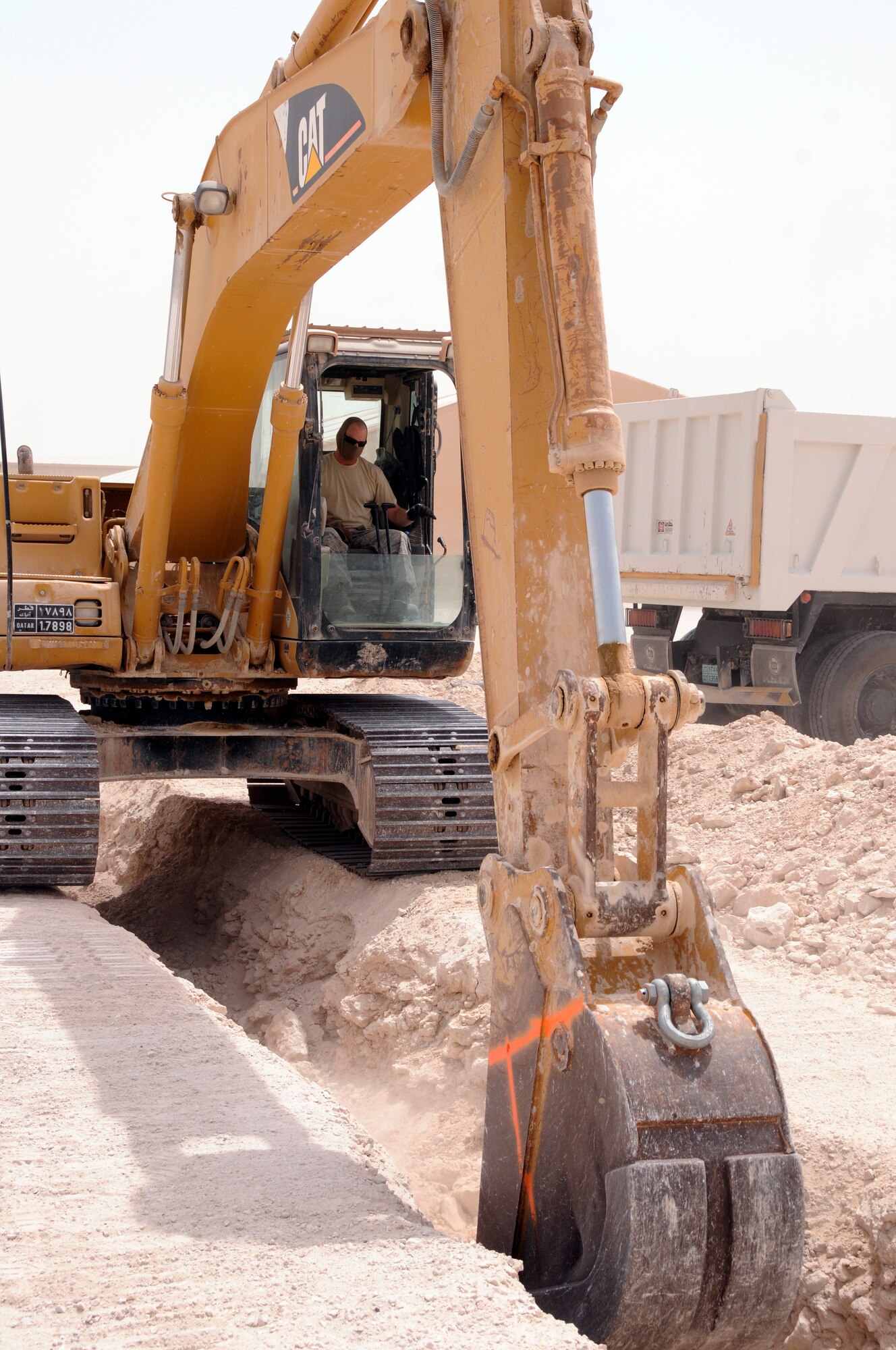 Tech. Sgt. Camon Tucker, 379th Expeditionary Civil Engineer Squadron operates an excavator to dig a trench Aug. 13, 2008, at an undisclosed air base in Southwest Asia.  Sergeant Tucker, a pavement and construction operator clears a trench that will be used for laying communication cable for the Royal Air Force unit here. Sergeant Tucker hails from Albuquerque, N.M. and is deployed from F. E. Warren Air Force Base, Wyo., in support of Operations Iraqi Freedom, Enduring Freedom, and Joint Task Force - Horn of Africa.  (U.S. Air Force photo by Tech. Sgt. Michael Boquette/Released)