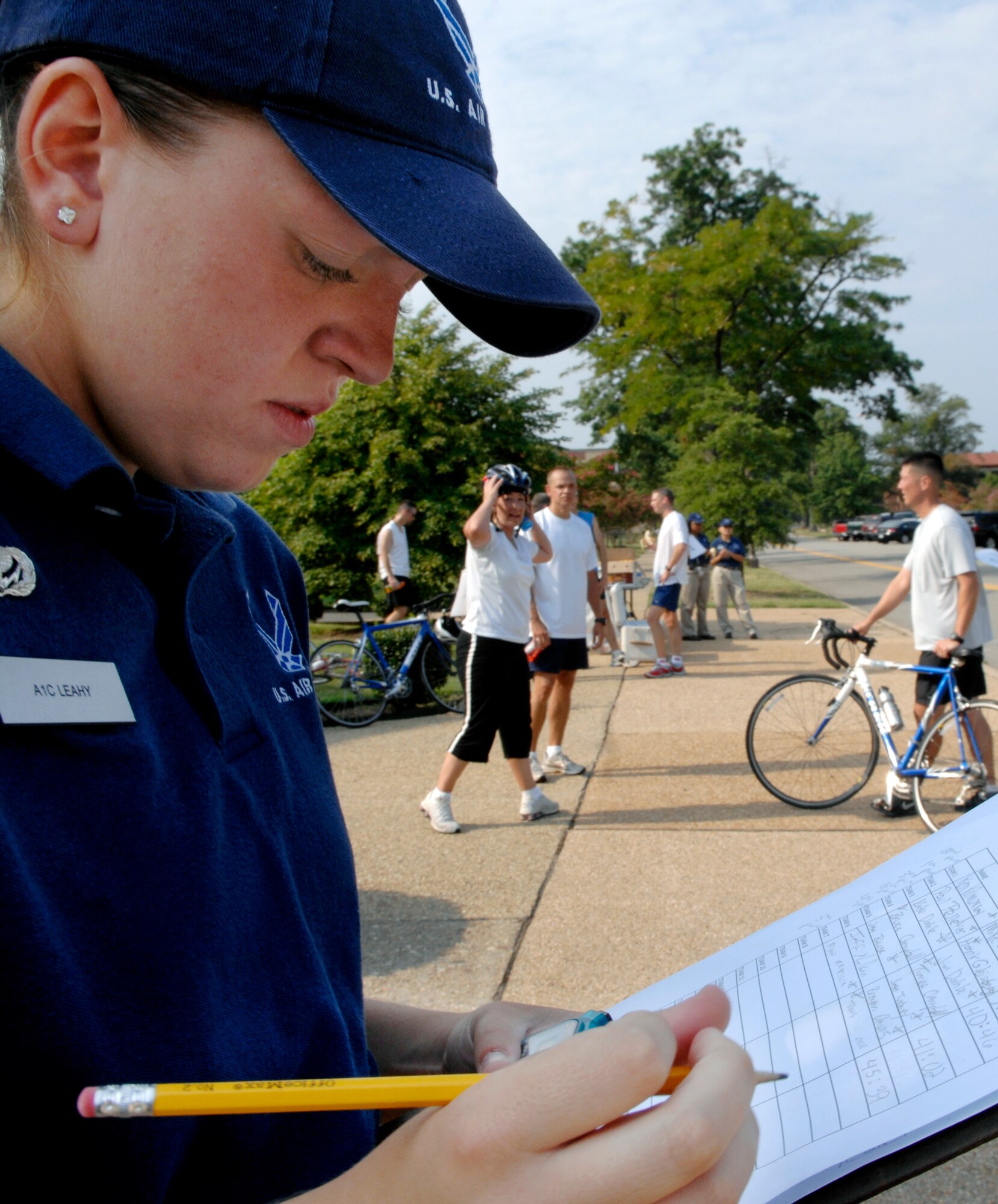 LANGLEY AIR FORCE BASE, Va. --  Airman 1st Class Catherine Leahy, 1st Force Support Squadron fitness specialist, records final times after participants cross the finish line of a duathlon sponsored by the 1st Force Support Squadron Aug. 15.  A duathlon is an eight mile exercise designed to challenge each participant's physical endurance with cycling and running.  The 1st FSS organizes an event monthly to continue encouraging physical fitness as the Air Force exercises the fit to fight mentality.  (U.S. Air Force photo/Senior Airman Vernon Young)