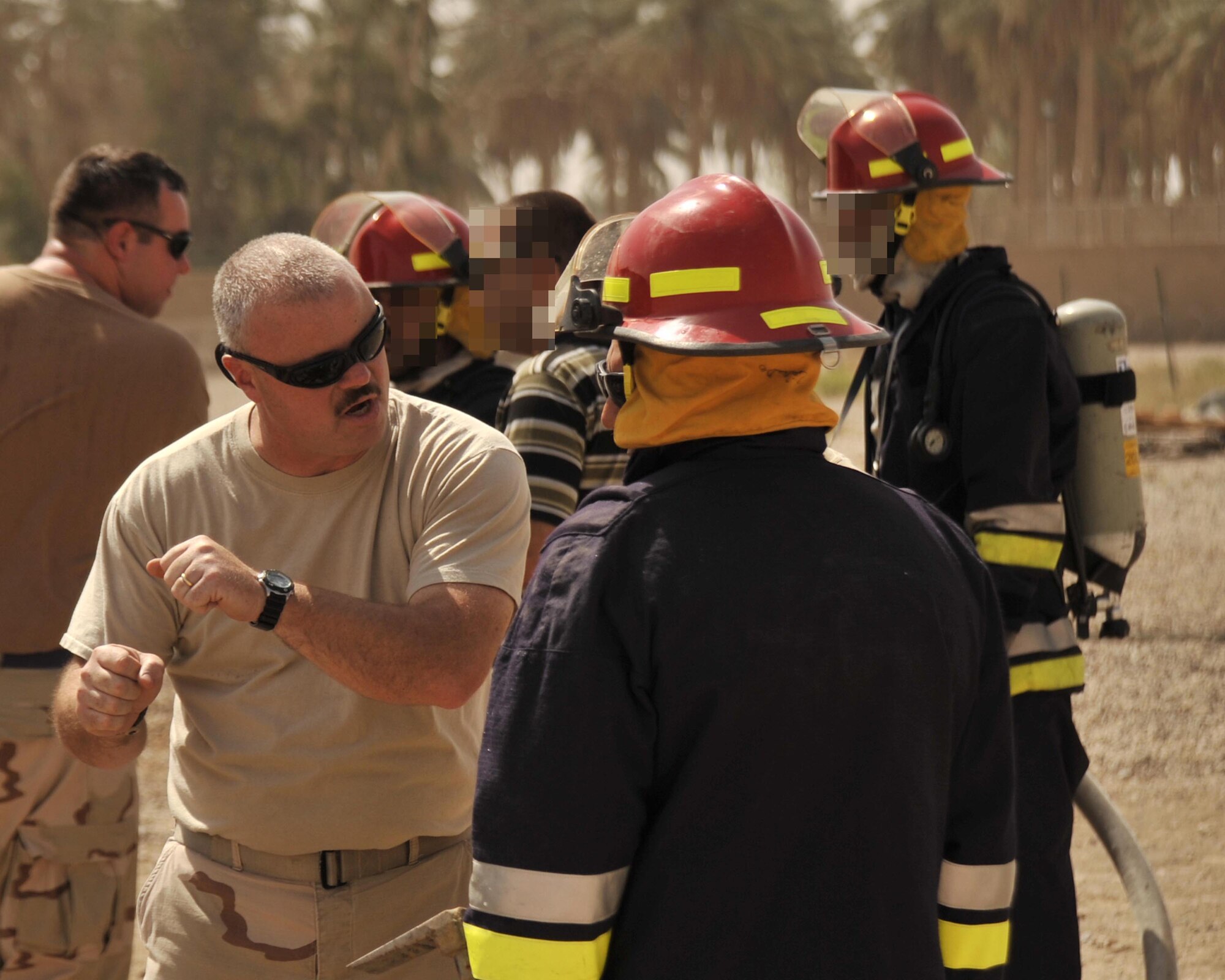 8/14/2008 - BAGHDAD, Iraq - Tech. Sgt. Don Edgar, 447th Expeditionary Civil Engineer firefighter, instructs an Iraqi firefighter about how to properly advance on a structure fire. The Airman firefighters, from near-by Sather Air Base, assisted the Iraqi fire department with live-burn training in a special secure compound for the families of Iraqi workers who assist with the rebuilding of their country. The Iraqi firefighter?s identities are concealed to protect them from insurgent activities. Sergeant Edgar is a New York Air National Guard Airman deployed from the 174th Fighter Wing in Syracuse. When he is not wearing his Air Force firefighter uniform, Sergeant Edgar serves as a state corrections officer. (U.S. Air Force Photo by Master Sgt. Brian Davidson)