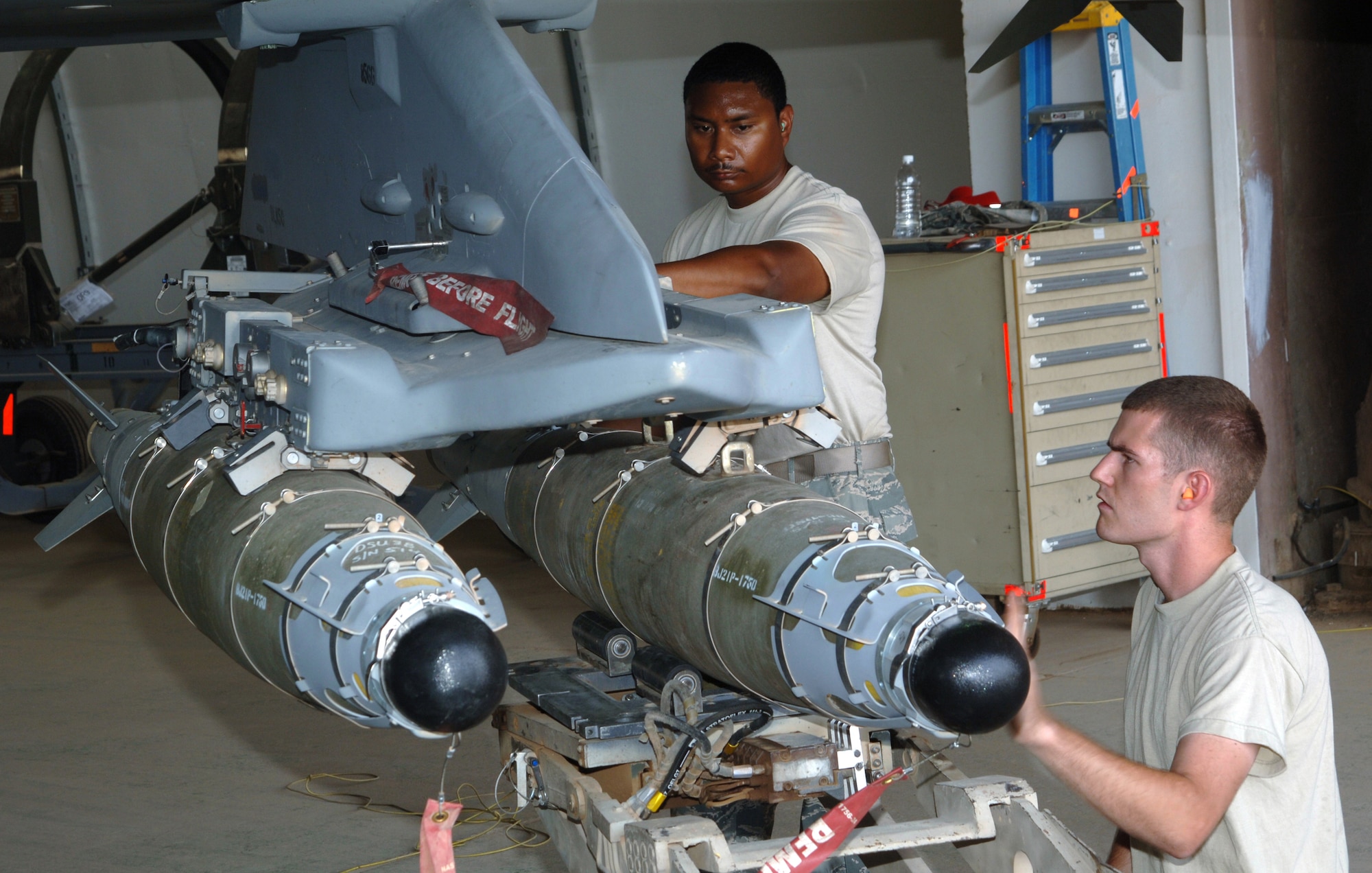 JOINT BASE BALAD, Iraq -- Staff Sgts. Michael Jackson and Anthony Bagen align a 500-pound GBU-54 Laser Joint Direct Attack Munition before connecting it to an F-16 Fighting Falcon here Aug. 14. Two F-16 pilots with the 77th Expeditionary Fighter Squadron here executed the first-ever combat employment of a GBU-54 Aug. 12 against a moving enemy vehicle in Diyala province to support a combined Iraqi army and U.S. Marine operation. Sergeant Bagen, a weapons load crew chief with the 77th EFS, is originally from Tampa, Fla. Sergeant Jackson, a weapons load crewmember with the 77th EFS, is originally from Union Springs, Ala. Both are deployed here from Shaw Air Force Base, S.C. (U.S. Air Force photo/Tech. Sgt. Erik Gudmundson)