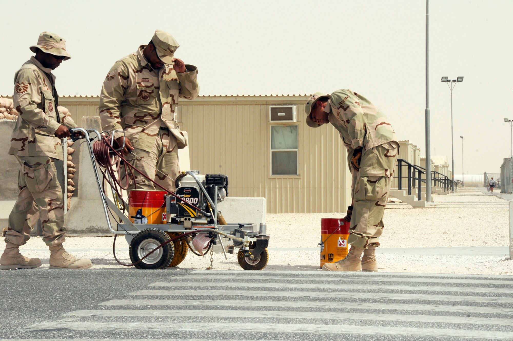 Staff Sgt. Ricardo McCall, from Travis Air Force Base, Calif., secures a Power Liner 2800 as Senior Airman Chris Gautier, from McChord AFB, Wash., pulls the starter cord and Airman 1st Class Shane Harding, from Grand Forks AFB, N.D., grabs a paint can Aug. 13, 2008. The three airmen from the 379th Expeditionary Civil Engineer Squadron structure shop are preparing to repaint crosswalks in a housing area at an undisclosed location in Southwest Asia. Sergeant McCall is a native of Montgomery, Ala., while Airman Gautier is from Baton Rouge, La., and Airman Harding hails from Alamogordo, N.M. All are deployed in support of Operations Iraqi Freedom, Enduring Freedom and Joint Task Force-Horn of Africa. (U.S. Air Force photo by Tech. Sgt. Michael Boquette)