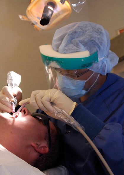 KUNSAN AIR BASE, Republic of Korea --Senior Airman Charles Powell, a dental technician with the 8th Medical Operations Squadron, uses an ultrasonic scaler to clean a patient's teeth here Aug. 14. (U.S. Air Force photo by Senior Airman Dana Hill)