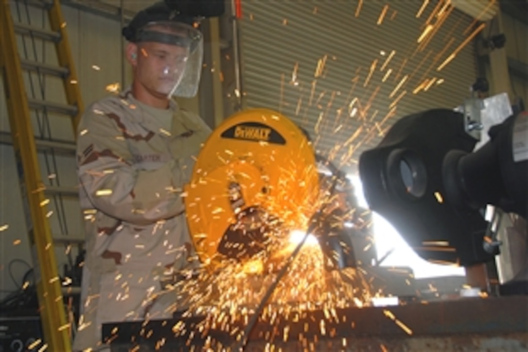 U.S. Air Force Airman 1st Class Mack Carter uses a metal chop saw to cut a square stock for a window frame, Southwest Asia, Aug. 13, 2008. The window frame will be used for additional security. Carter is assigned to the 735th Civil Engineer Squadron, deployed from Ramstein Air Base, Germany.