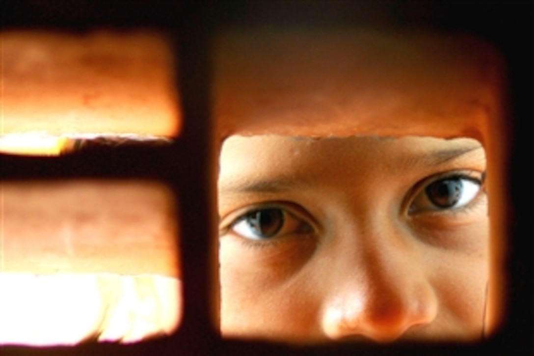 A young girl peers through bricks in the auditorium of Juan Comenius High School during a Continuing Promise 2008 humanitarian assistance project in Puerto Cabezas, Nicaragua, Aug. 13, 2008. The amphibious assault ship USS Kearsarge 3 is deployed as the primary platform for supporting the Caribbean phase of Continuing Promise, an equal-partnership mission between the United States, Canada, the Netherlands, Brazil, Nicaragua, Panama, Colombia, Dominican Republic, Trinidad, Tobago and Guyana. 