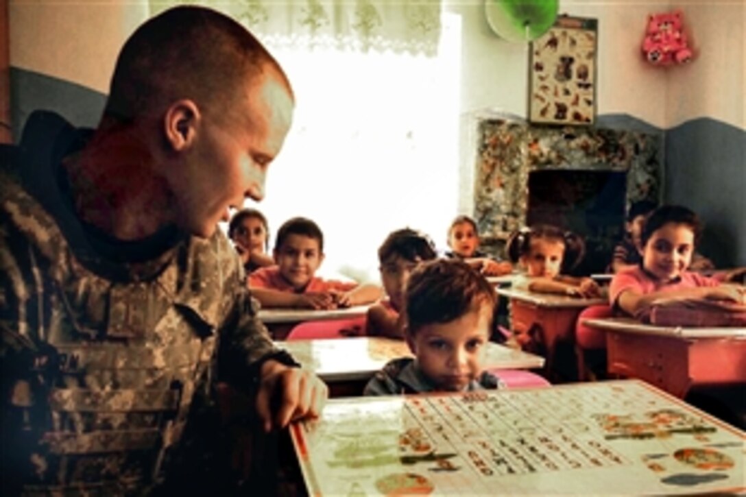 U.S. Army 2nd Lt. Ben Dalton, speaks with an Iraqi boy in a classroom at Alethar Elementary School in Amariyah, Iraq, Aug. 12, 2008. Dalton is assigned to the 4th Infantry Division's Comanche Troop, 4th Squadron, 10th Cavalry Regiment. 

