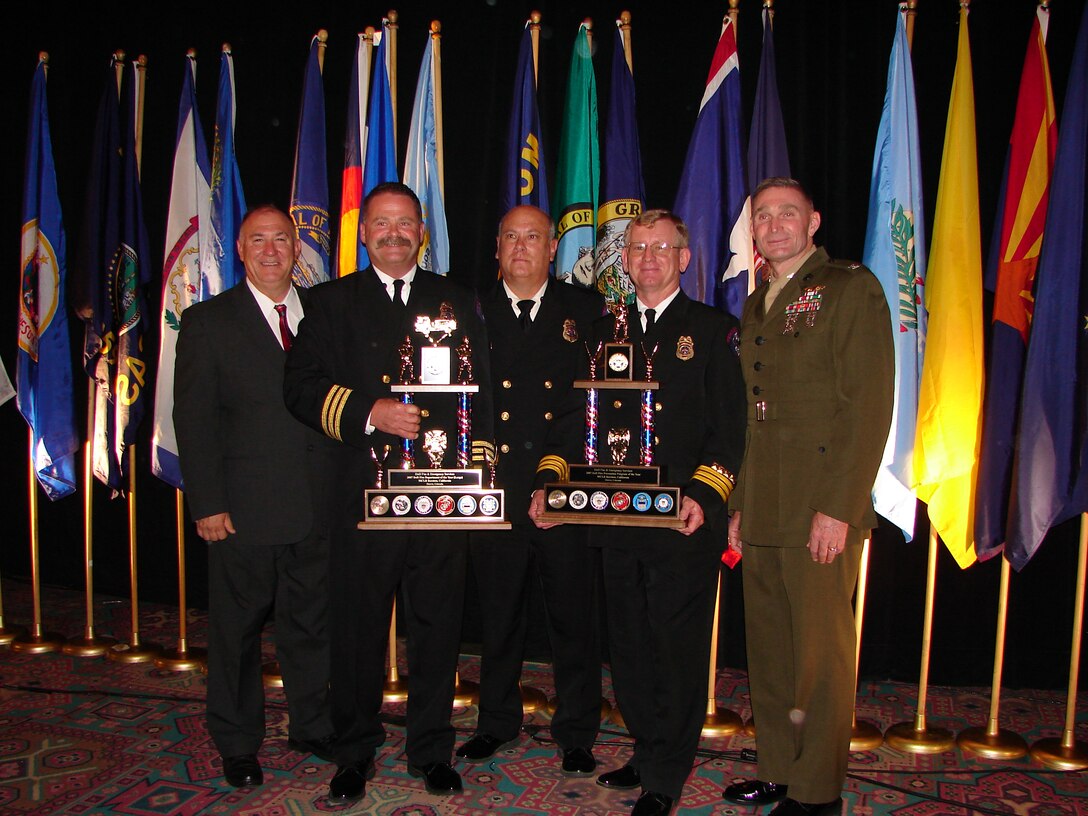 Marine Corps Logistics Base Barstow, Calif., representatives (left to right) Danny Strand, director, Security and Emergency Services, Thomas Thompson, assistant chief of operations, Fire and Emergency Services, Robert Wyman, fire chief, FES, Terry Jenkins, assistant chief of fire prevention, FES and Col. Kenneth Enzor, commanding officer, MCLB Barstow, proudly display the hardware the installation was awarded at the annual Department of Defense Fire and Emergency Services Awards Aug. 15.  In a victory of David versus Goliath proportions, MCLB Barstow, the smallest fire department competing in "large" category, triumphed over organizations from around the globe to be named the Large Fire Department of the Year and Fire Prevention Program of the Year DoD-wide.