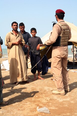 SADAMIYAH PENINSULA, Iraq (August 14, 2008) – An Iraqi soldier with Iraq’s 1st Battalion, 2nd Brigade, 1st Iraq Army Division, talks with local fishermen as he patrols through a fish market Aug. 15, during a 72-hour Iraqi-led sweep operation.  (Official U.S. Marine Corps photo by Lance Cpl. Scott Schmidt)