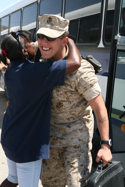 Lance Cpl. Jeremy Burnside, a reserve Marine from Company F, 2nd Battalion, 24th Marine Regiment, is hugged by an Official Hugger while he steps off the bus at the Combat Center Aug. 16, 2008. 2/24 is a reserve unit that had more that 1,000 Marines deployed for seven months to Al Anbar Province. The reserve unit’s home base is Chicago.