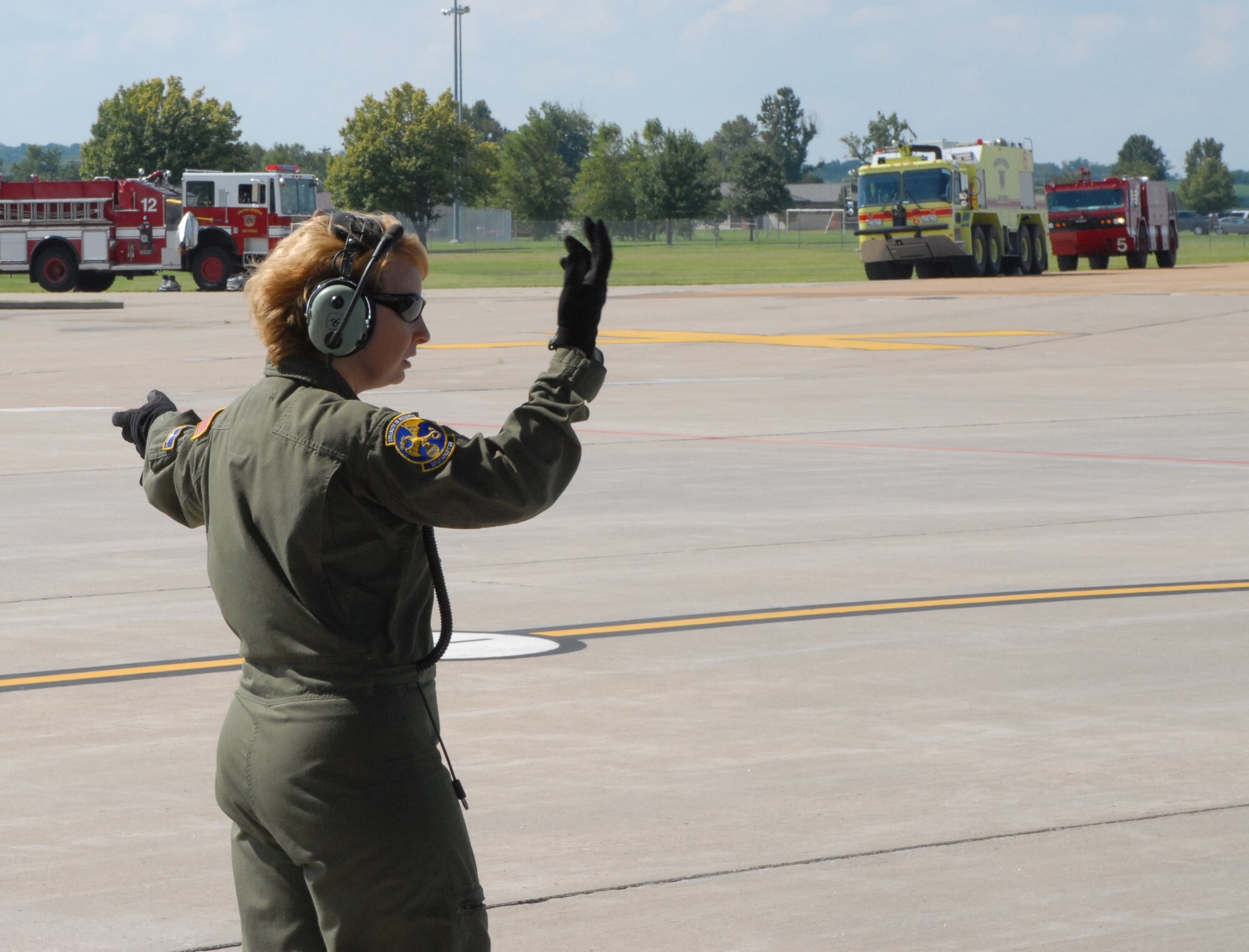 A loadmaster from the 349th Air Mobility Wing directsly flightline maintenance members as they move equipment to the right.  In the background, Scott Air Force Base firetrucks standby as they watched the C-17 from Travis Air Force Base, Calif.  The wing is in town to help with Aeromedical Evacuation Jamboree 2008.