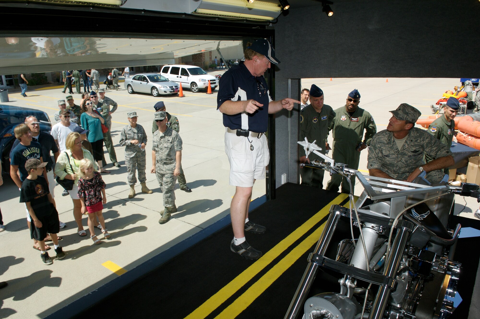 While public visitors look through the big picture window on the left, Don Mackey (left), talked with Brig. Gen. James J. Jones about the Air Force Orange County Chopper on display Aug. 14 at Dillon Brothers Harley-Davidson for Air Force Week in the Heartland in Omaha, Neb. Mr. Mackey manages the display and is one of two people who represent the Air Force on the title of the motorcycle. General Jones is the commander of the 55th Wing at Offutt Air Force Base, Neb. Built in 2005, the chopper has a 131 cubic inch engine that generates 150 horsepower. From end to end it stretches 10 feet 3 inches.  It features a six-speed Baker right-hand drive that puts power to the 300 series Avon Venom rear tire. The color scheme is based on the F-22 Raptor.  (U.S. Air Force photo/Lance Cheung)