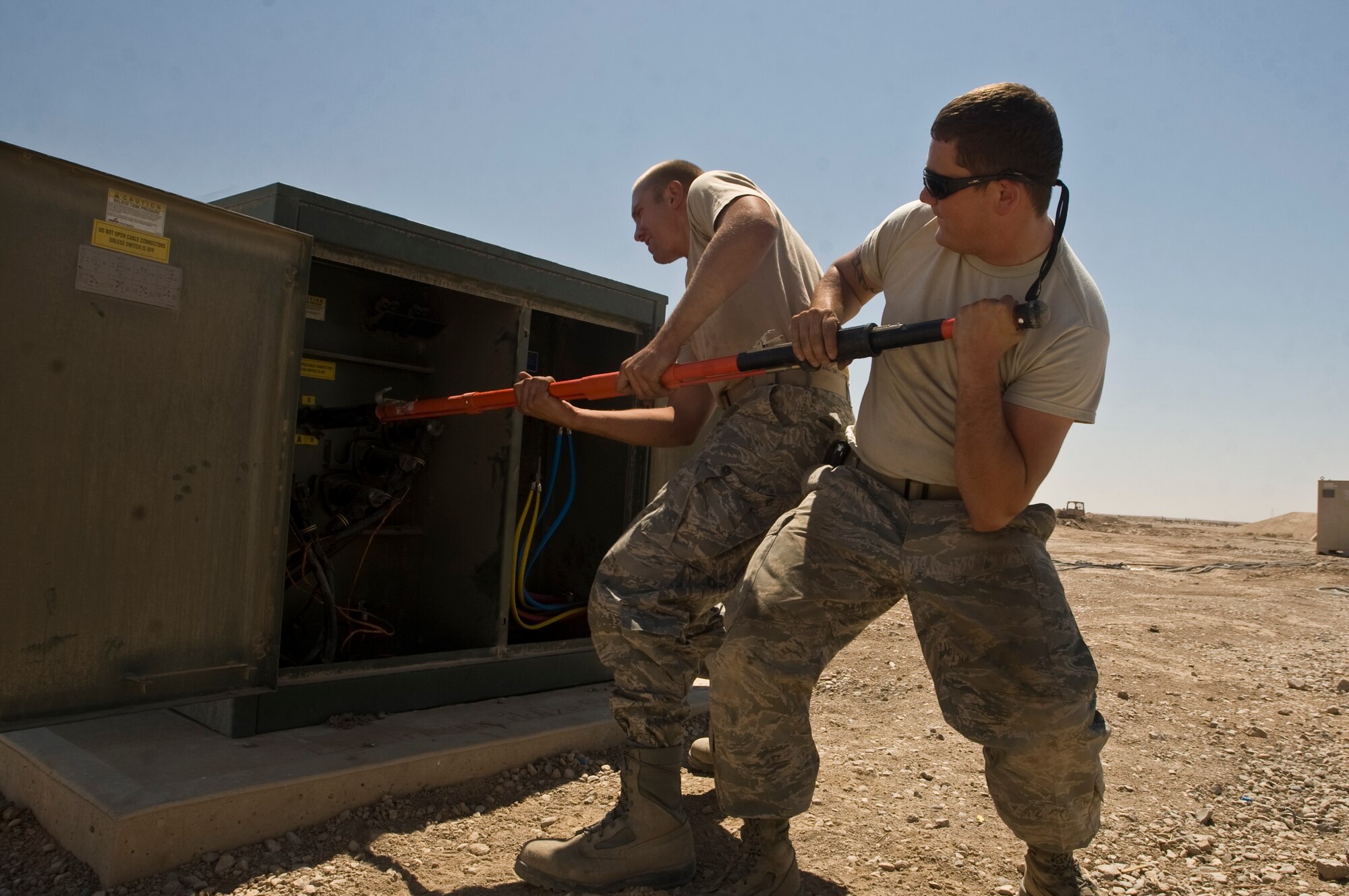 ALI BASE, Iraq -- Staff Sgt. Christopher Holman and Senior Airman Curtis Barnhill, 407th Expeditionary Civil Engineer Squadron electricians, switch on a power unit Aug. 15, 2008. Power cables attached to the shelter housing the Predators recently caught fire and were replaced by electricians of the 407th ECES in five hours. The Predators are vital to the Global War on Terrorism and must be kept cool and ready to go while not flying. Sergeant Holman is deployed from Malmstrom Air Force Base, Mont. Airman  Barnhill is deployed from F.E. Warren Air Force Base, Wyo. (U.S. Air Force photo/Airman 1st Class Christopher Griffin)