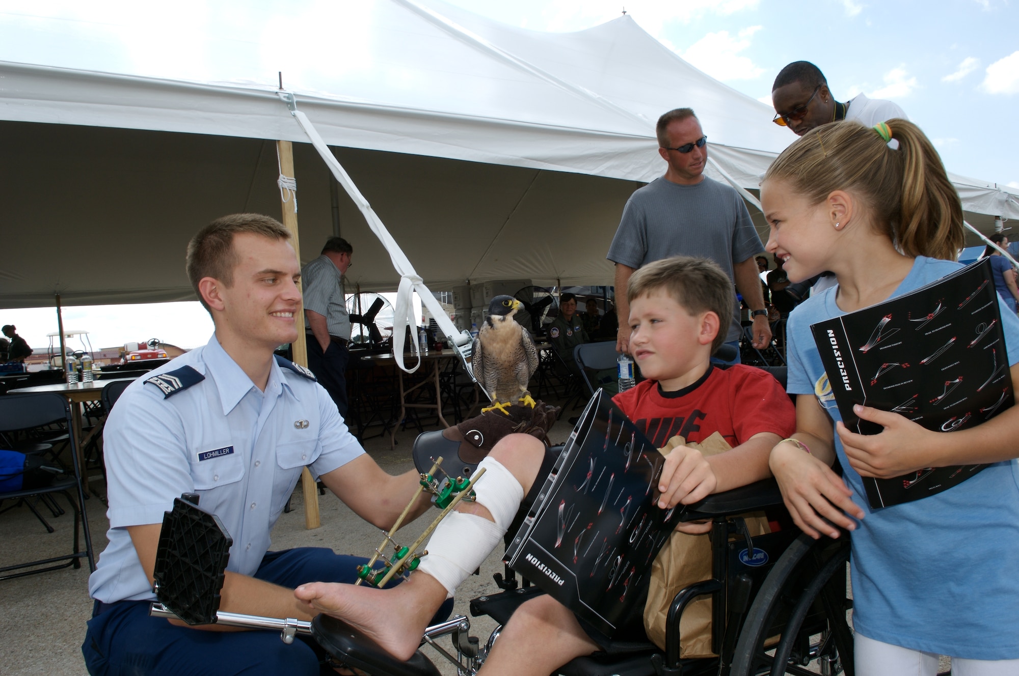 Cadet 2nd Class Corey Lohmiller and "Havoc" visits with Henry (red shirt) and his sister Mallory Wise during a special needs airshowe Aug. 15 at Offutt Air Force Base, Neb. Cadet Lohmiller attends the U.S. Air Force Academy, and "Havoc" is a Peregrine falcon. (U.S. Air Force photo/Lance Cheung)
