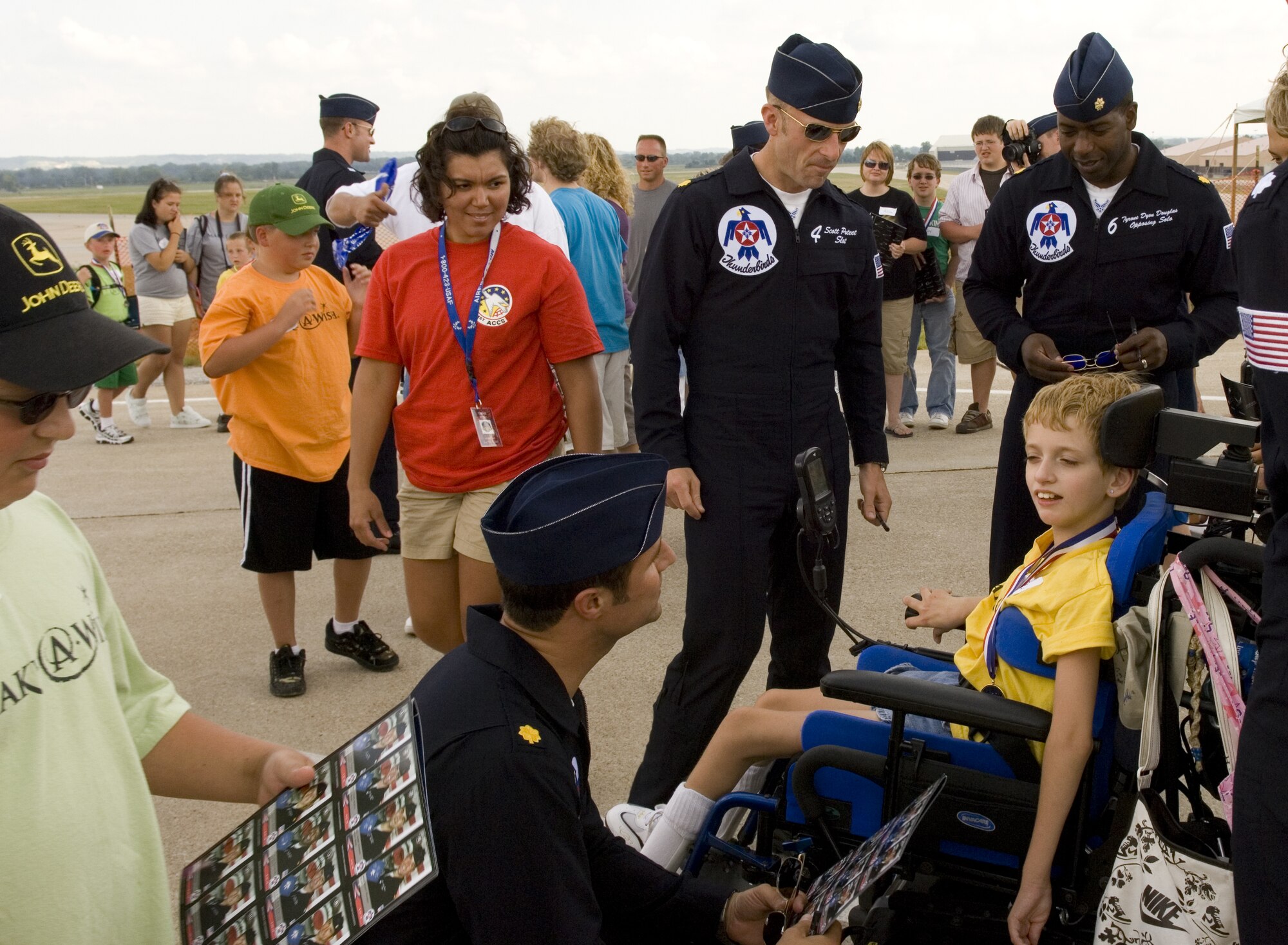 Majors Kirby Ensser, Scott Poteet and Dyon Douglas spend time with special needs visitors who were treated to a complete airshow Aug 15 at Offutt Air Force Base, Neb. Majors Ensser, Poteet and Douglas are Thunderbirds 3, 4 and 6, with the Air Force Demonstration Squadron.  (U.S. Air Force photo/Lance Cheung)
