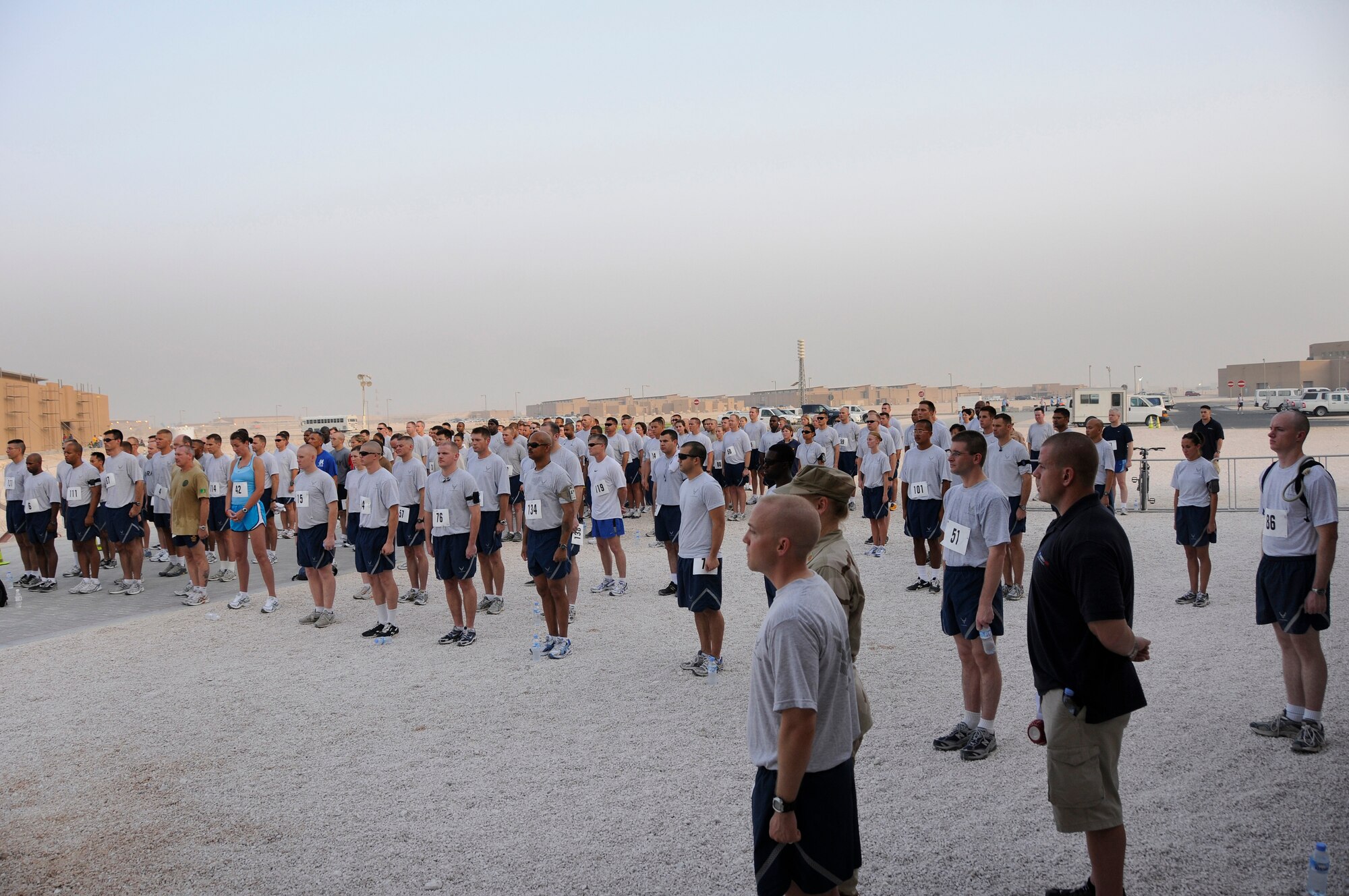 Runners pay respects during the playing of taps prior to the “Run for the Fallen 5K” sponsored by the 379th Expeditionary Force Support Squadron Sunday, Aug. 17, 2008, at an undisclosed air base in Southwest Asia.  183 runners from the Army, Navy, Air Force and Marines as well as coalition partners participated in the run honoring those who have made the ultimate sacrifice in the Global War on Terrorism. (U.S. Air Force photo by Tech. Sgt. Michael Boquette/Released)