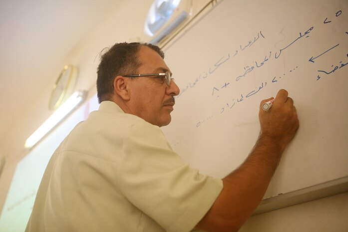 Providing visual aiding notes, Waleed Hameed Salaiman, a senior trainer, teaches Iraqi leaders the fundamentals of heading a local government during a government training class in Rutbah, Iraq, Aug. 18. Salaiman, from Fallujah, Iraq, was one of many instructors who volunteered to teach the leaders fundamentals ranging from government structure to economics.::r::::n::